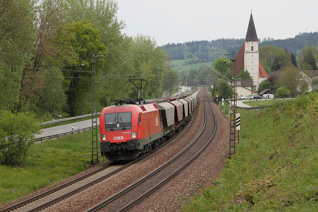 BB-Taurus 1116-034 mit Gterzug vor der Kirche von Hausbach zwischen Passau und Vilshofen bei leider bedecktem Himmel (am 27. Apr. 2011). 