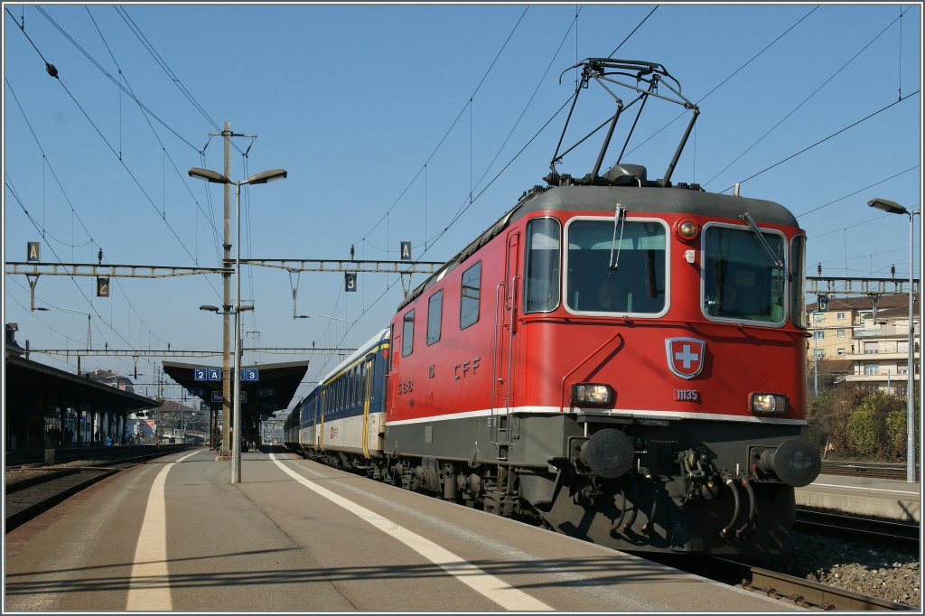 Re 4/4 II 11135 mit einem RE in Renens. 
3. Feb. 2012