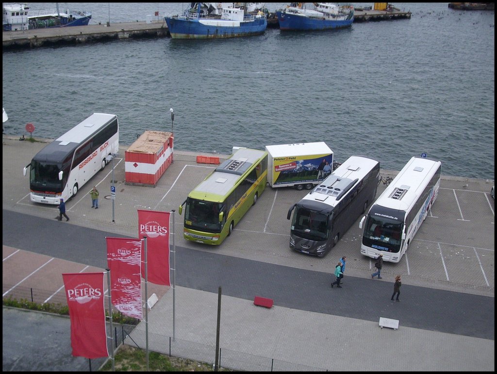 Setra 415 HDH vom Reisebro Buck aus Deutschland und Setra 415 GT-HD von Wricke-Touristik aus Deutschland und VDL Futura aus Deutschland und MAN Lion's Coach von Melskotte aus Deutschland im Stadthafen Sassnitz. Dank dem Hngerzug stehen  die drei schief in der Parklcke.