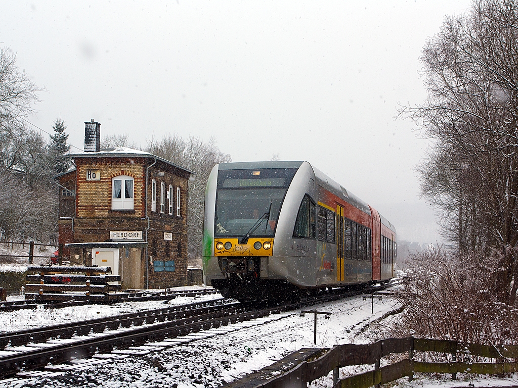 Und wieder, wie mein Freund Stefan es nennt, lsst der Winter seinen Abfall fallen - 
Ein Stadler GTW 2/6 (VT 118) der Hellertalbahn fhrt am 17.03.2013, bei Schneefall, von Herdorf weiter in Richtung Neunkirchen. 

Links ist das 1901 gebaute Stellwerk Herdorf Ost (Ho).