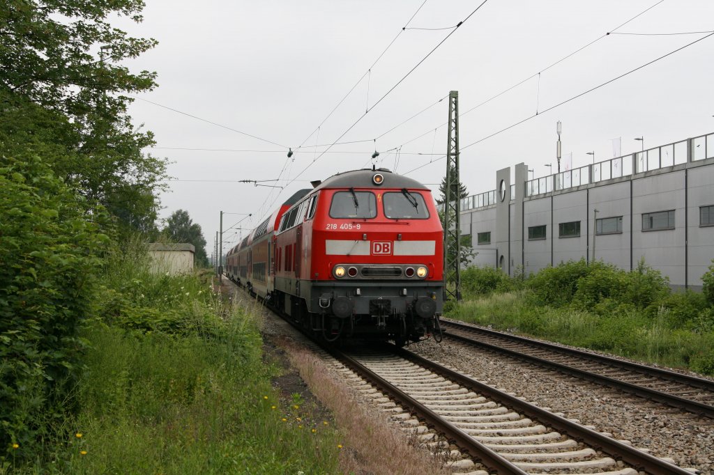 Unter dem grauen Himmel Oberbayerns fhrt 218 405-9 am Vatertag (02.06.11) mit einem RE nach Mhldorf durch Poing.