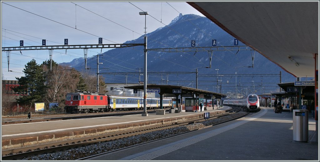 Whrend die Re 4/4 mit ihrem EW I/II Regio die Sonntagsruhe geniesst, rauscht der ETR 610 ohne Halt durch Martigny.
27. Jan. 2013