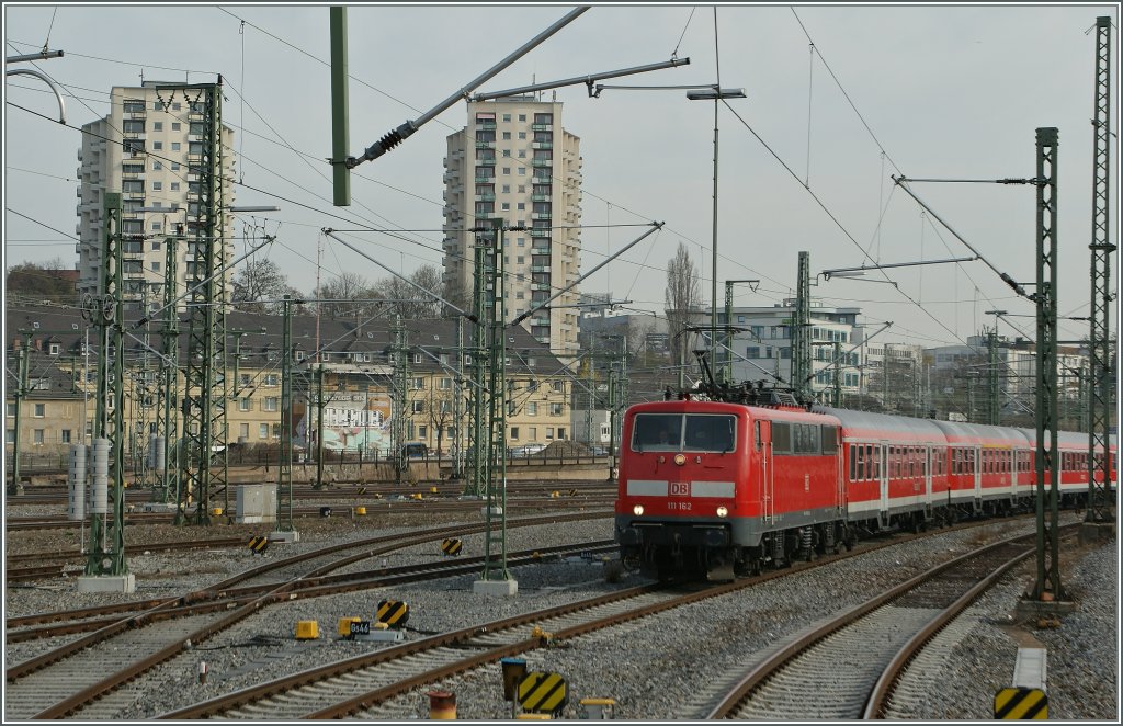 Wie gut werden auch im Fernverkehr noch Wagen eingesetzt, die Fenster zum ffnen haben und so der Versuch unternommen werden kann, Zge an sonst nicht zugngliche Stellen fotografieren zu knnen. 
Die DB 111 162 mit einem Zug des GB Regio im Vorfeld des Stuttgarter HBF, das Bild entstand aus dem IC 2319 am 29.03.2012