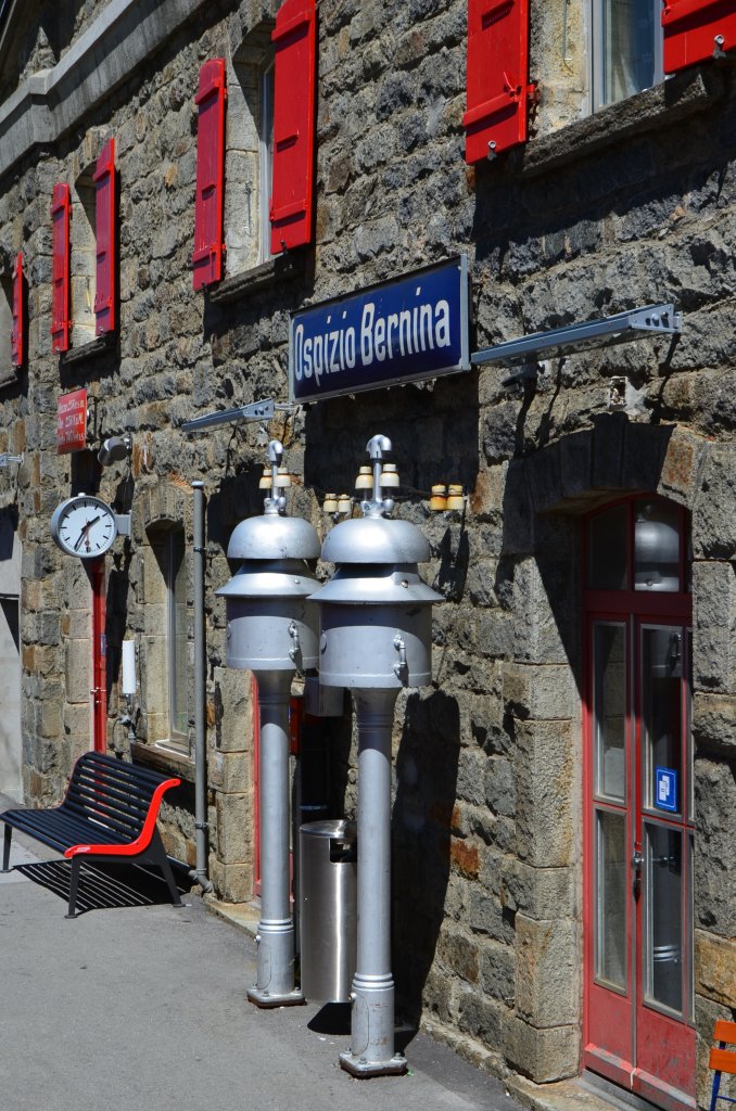 Wie zwei Zinnsoldaten stehen die Ablutewerke vor dem Stationsgebude Ospizio Bernina am 11.08.2012 um 13:36 Uhr.