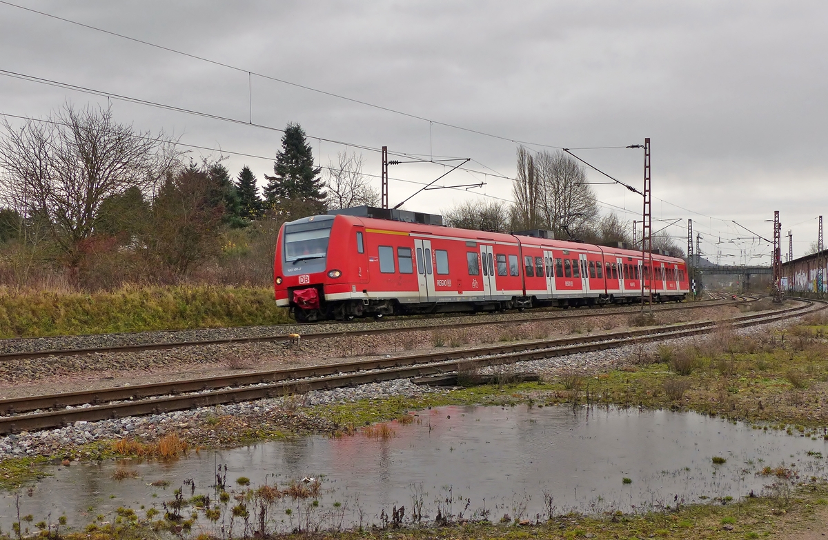 . 425 130-2 ist am 20.12.2014 zwischen Bous und Ensdorf unterwegs und htte es nicht angefangen zu regnen, htte es sogar eine Spiegelung des Quietschis in der Pftze gegeben. (Jeanny)