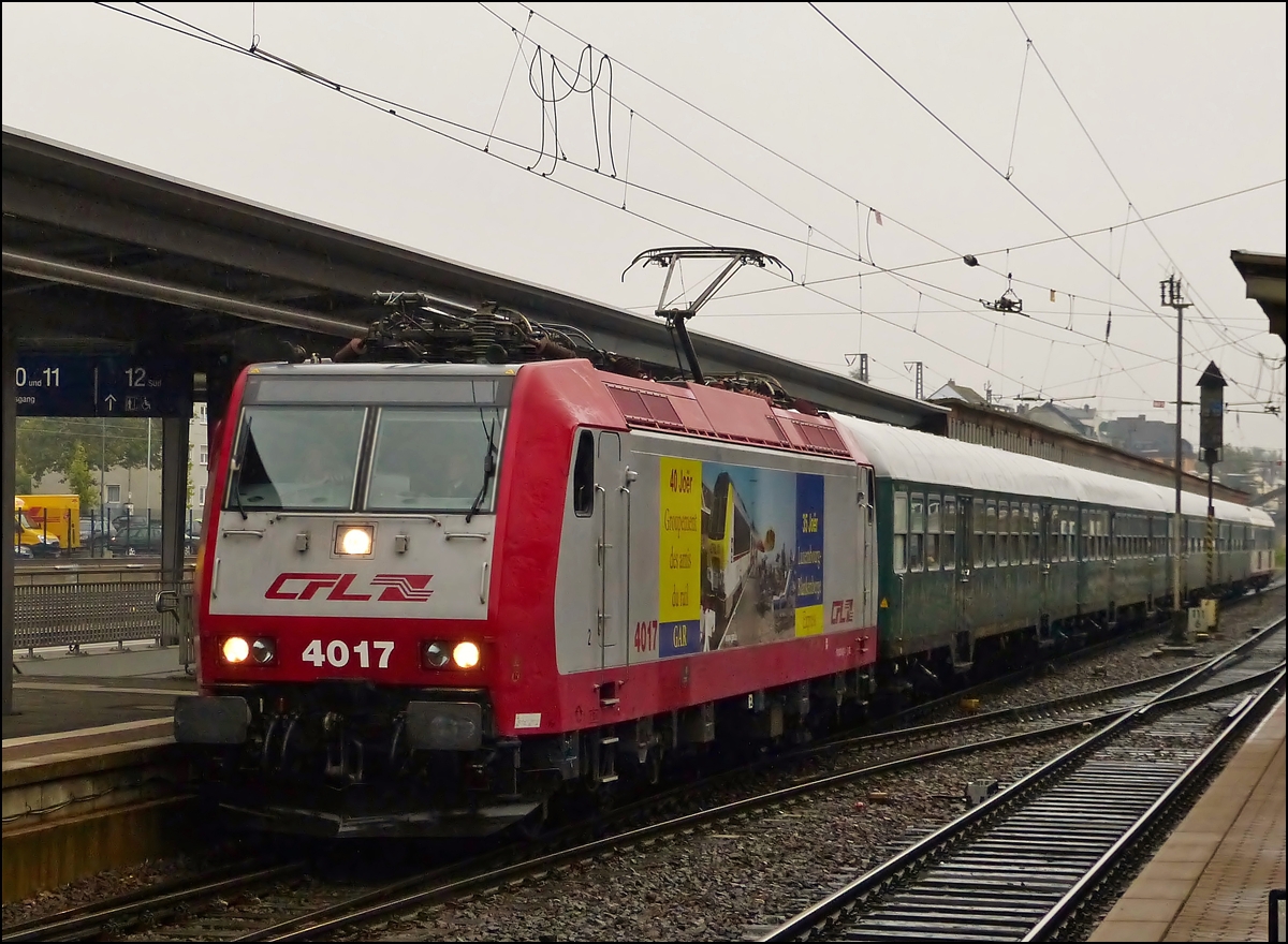 . Am frhen Morgen bei strmenden Regen fhrt der G.A.R (Groupement des Amis du Rail) Sonderzug nach Rdesheim in den Hbf von Trier ein. 05.10.2013 (Hans)

Der Zug besteht aus der CFL 4017, 4 Wegmann und dem Rendez-Vous Wagen. Die Werbung der 4017 ist uerst passend, widmet sie sich dem 40 jhrigem Bestehen des Vereins Groupement des Amis du Rail (G.A.R.) und dem 35 jhrigen Bestehen des Blankenberg Express, welcher auch von diesem Verein ins Leben gerufen wurde.
