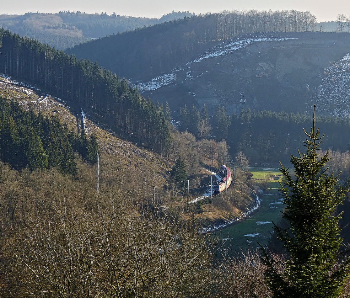 . Suche den Zug - An der Strae zwischen Cinqfontaines und Sassel hat man fr einen kurzen Augenblick eine Aussicht auf die Nordstrecke. Der RE 3814 Luxembourg - Troisvierges fhrt am 11.02.2015 durch das tiefe Tal der Woltz zwischen Maulusmhle und Troisvierges. (Jeanny)