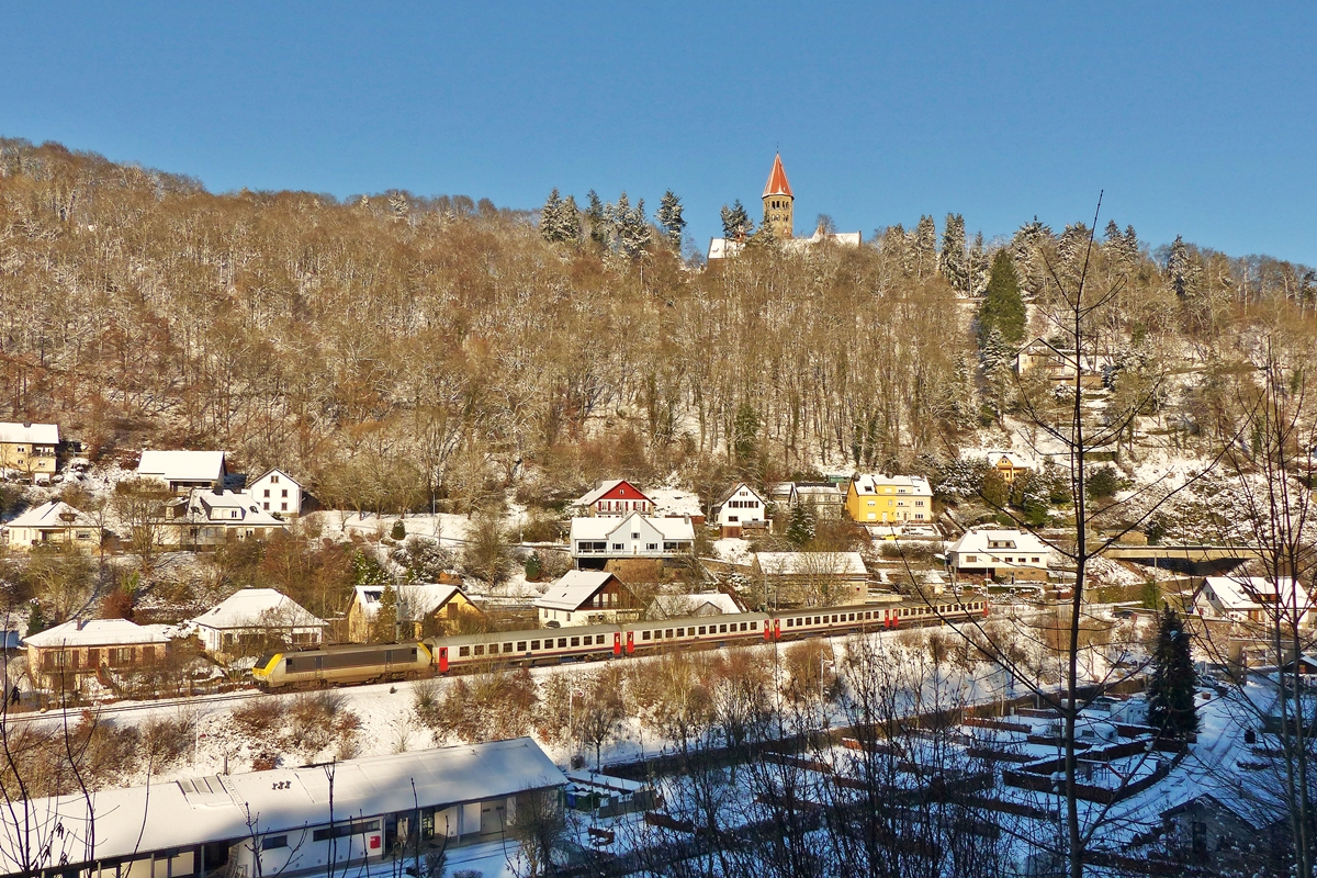 . Winter in Clervaux - Die Fotostelle in der  Welzerstrooss  in Clervaux bietet nur noch sehr wenige Mglichkeiten den Zug unverdeckt abzulichten. Die leider auch sehr schmutzige 3013 mit dem IC 110 Liers - Luxembourg am Haken fhrt unter der Benediktiner Abtei St Maurice am Campingplatz in Clervaux vorbei. 28.12.2014 (Jeanny)