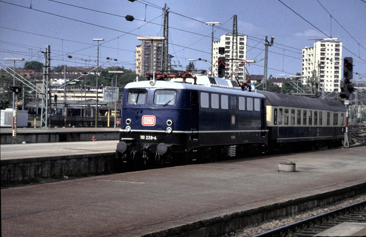 110 228-4 rangiert in Stuttgart mit einem Schnellzug-Wagen mit Gepäckraum Typ BDms 271-273 an 04.05.1993.