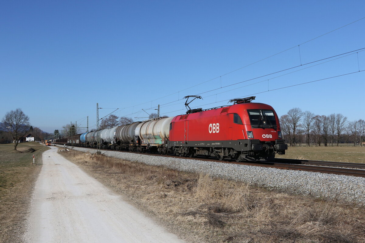 1116 140 mit einem gemischten Gterzug auf dem Weg nach Freilassing am 9. Mrz 2022 bei bersee am Chiemsee.