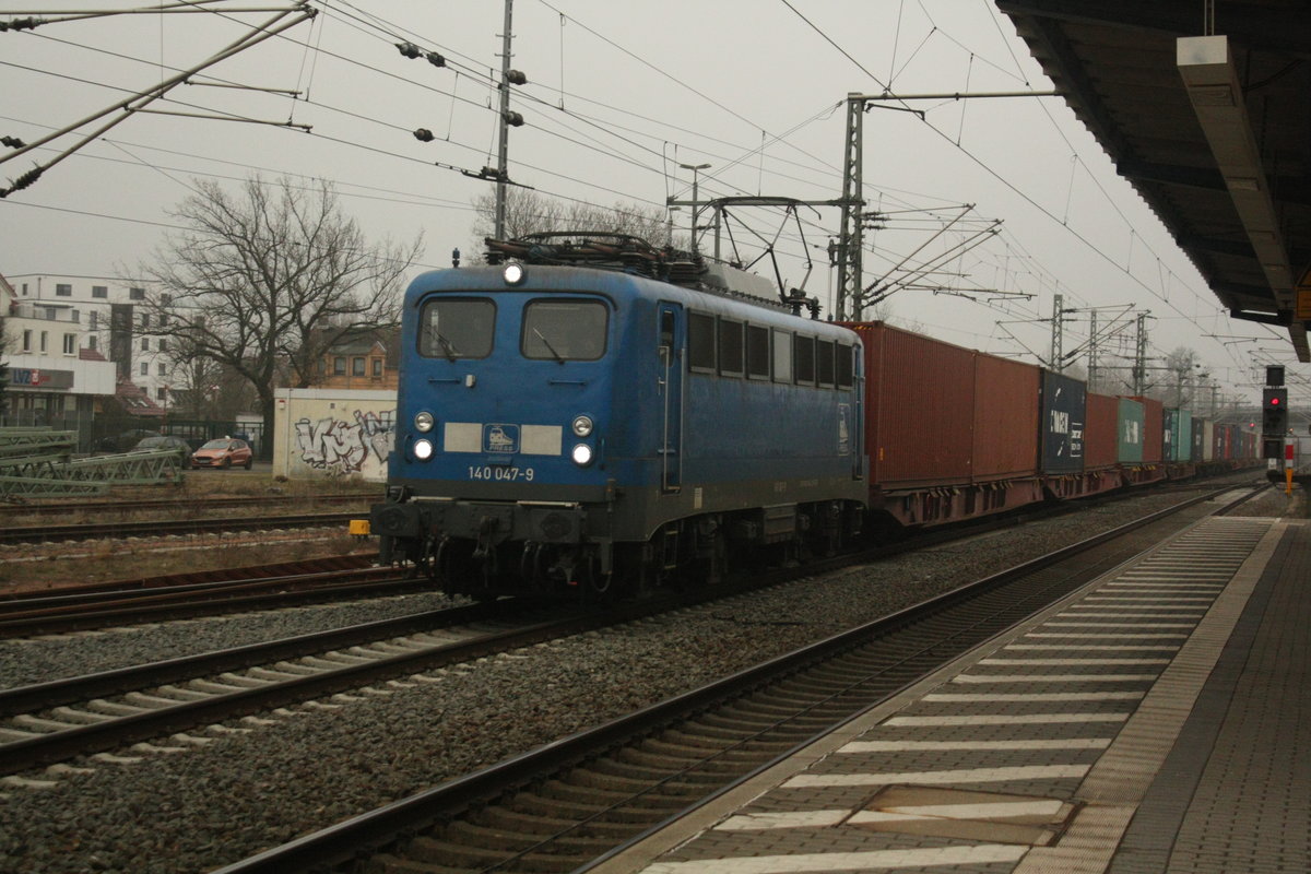 140 047 der PRESS mit einem containerzug bei der Durchfahrt im Bahnhof Delitzsch unt Bf am 4.3.21