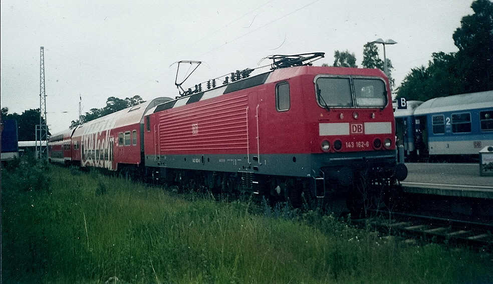 143 162 vor einer Regionalbahn nach Bergen/Rügen in Binz.