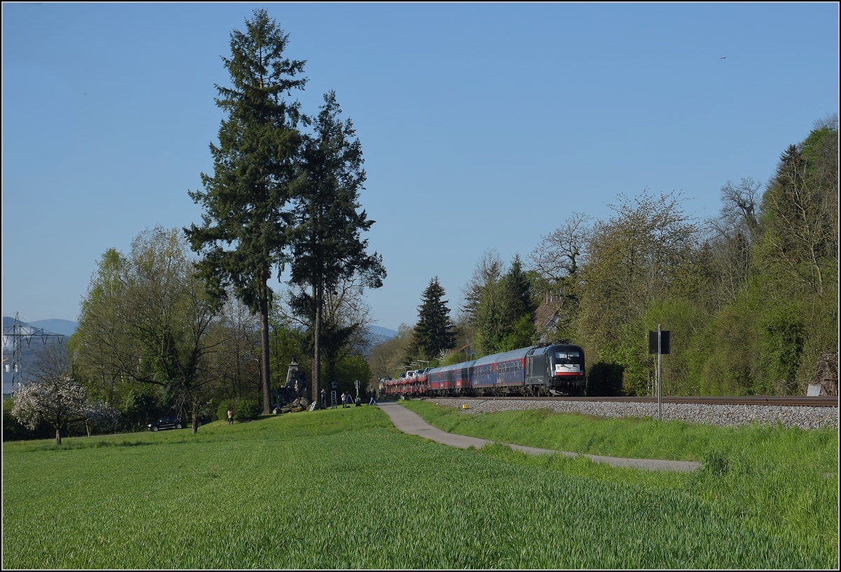 182 524-9 am Zugschluss des Autozuges auf seinem Umweg über die Hochrheinbahn. Beuggen, April 2019. Man beachte auch die vielen Bahn-Fotografen im Bild, die das Ereignis zu schätzen wussten.