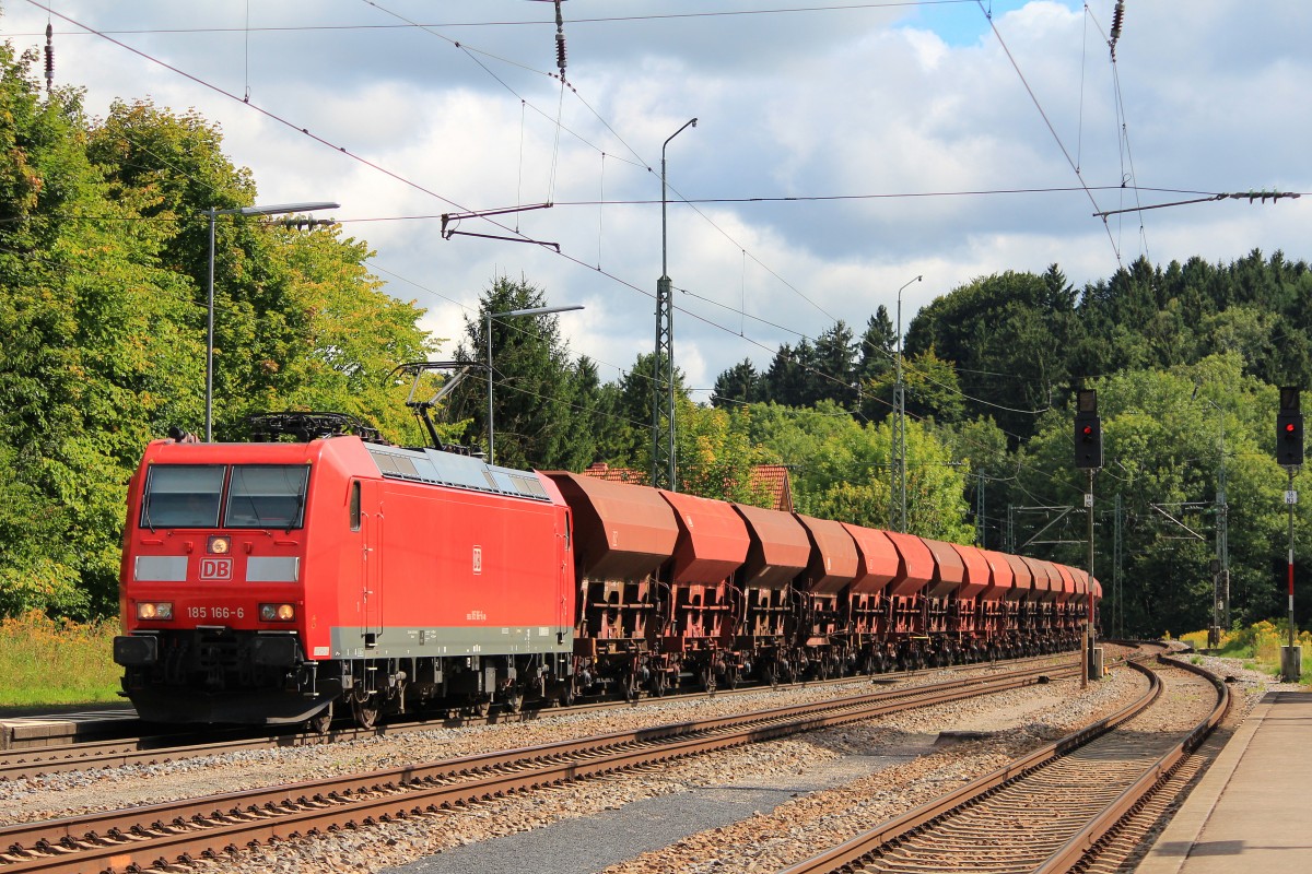 185 166-6 durchfährt am 9. April 2012 mit einem Schüttgutwagenzug den Bahnhof von Assling.