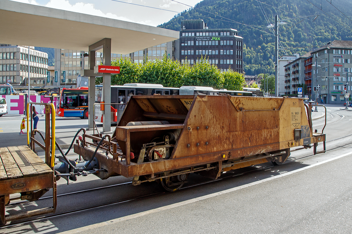 2-achsiger Talbot Schotterwagen mit 1 offenen Plattform RhB Xc 9423, ex RhB Fd 8663, am 12.09.2017 am Bahnhofsvorplatz im Zugverband eingereiht in einem aus Arosa kommenden Bauzug.

Diese Schotterwagen wurden 1965 von der Waggonfabrik Talbot in Aachen bebaut. Im Jahr 2004 wurden sie neu nummeriert, Fd 863 wurde nun zum Xc 9423.
 
TECHNISCHE DATEN:
Spurweite: 1.000 mm
Anzahl der Achsen: 2
Lnge ber Puffer: 7.990 mm
Achsabstand: 4.000 mm 
Hhe: 2.000 mm
Laufraddurchmesser: 750 mm (neu)
Eigengewicht: 7.380 kg
Ladegewicht: max. 15 t (bis 60 km/h) / 12 t (bis 70 km/h)
Max. Ladelvolumen: 9,0 m
zulssige Geschwindigkeit: 60 km/h / 70 km/h

Wagenbescheibung:
Diese Talbot Schotterwagen des Typs Fd werden zum Transport und zum anschlieenden direkten einbringen des Neuschotter ins Gleisbett verwendet. Entwickelt und gebaut wurden die Wagen von der Waggonfarbrik Talbot in Aachen. Die Wagen verfgen dank ihrer Bauart ber einen sehr niedrigen Schwerpunkt. Der Wagen besteht aus einem Chassisrahmen, an dem unten die beiden Achsen mit Federn, die Bremsausrstung und die Luftbehlter angebaut sind. Und darauf eine Mulde mit 9m Fassungsvermgen fr den Schotter. Am einen Wagenende befindet sich die Arbeitsbhne mit Handbremskurbel und den Dossierrdern fr die Entladung. Die Dossierrder ermglichen jede Kammer einzeln, mit genau der bentigten Menge zu entleeren, so lsst sich der Schotter bereits beim Entladen in der richtigen Menge dosiert, an der richtigen Stelle verteilen. Beim Entladen wird der Wagen langsam ber den neu zu schotternden Gleisabschnitt gezogen und durch die mehr oder weniger geffnete Entladevorrichtung, die sich nur gerade 35 cm ber Schienenoberkannte befindet, fllt der Schotter genau ins Gleisbett. Linke, Mitte und rechte Seites knnen dabei separat dossiert werden und das Schotterbett erhlt bereits die Grundform der charakteristischen Form mit den Erhhungen an den Rndern und flach im Bereich der Schwellen. Die definitive Form erhlt das Gleisbett anschlieend dann durch eine Schotterplaniermaschine.

Die Schotterwagen Fd eignen sich nicht nur fr Neuschotterung, sondern auch einfach bei einer Nachschotterung werden sie eingesetzt. Bei einer Nachschotterung ist es nicht immer zwingend notwendig, das Gleis noch mit der Schotterplaniermaschine nach zu bearbeiten. Die Fd verfgen ber eine durchgehende automatische Vakuumbremse mit 2-Stufigem Lastwechsel. Der Bremszylinder arbeitet auf jedes Rad, dass jeweils mit je zwei Bremskltzen ausgerstet ist. Die mechanische Handbremse wirkt nur auf die Achse bei der Arbeitsbhne. 