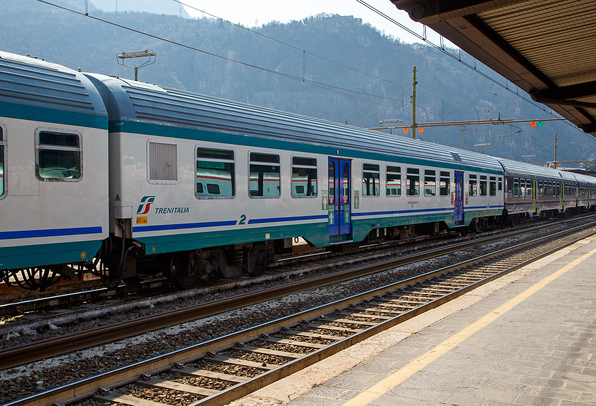 2. Klasse MDVC-Reisezugwagen (MDVC steht für Medie Distanze Vestiboli Centrali, deutsch für Mittlere Entfernungen in Ballungsräumen) 50 83 21-86 708-9 I-TI der Trenitalia, der Gattung nB am 26.03.2022 im Zugverband im Bahnhof Bozen / Bolzano.

Die den Wagen handelt es sich um in Italien hergestellte Eisenbahnwaggons die speziell für den Einsatz für mittlere Entfernungen wie z.B. RE (Regionalexpress Züge).

TECHNISCHE DATEN:
Spurweite: 1.435 mm
Länge über Puffer: 26.400 mm
Breite: 2.825 mm
Höhe: 3.965 mm
Drehzapfenabstand: 19.000 mm
Achsstand im Drehgestell: 2.400 mm
Laufraddurchmesser : 860 mm (neu)
Fußbodenhöhe: 1090 mm
Eigengewicht: 40 t
Sitzplätze: 82 (2. Klasse)
Höchstgeschwindigkeit: 160 km/h
Bremsbauart: Freno WU-R 
