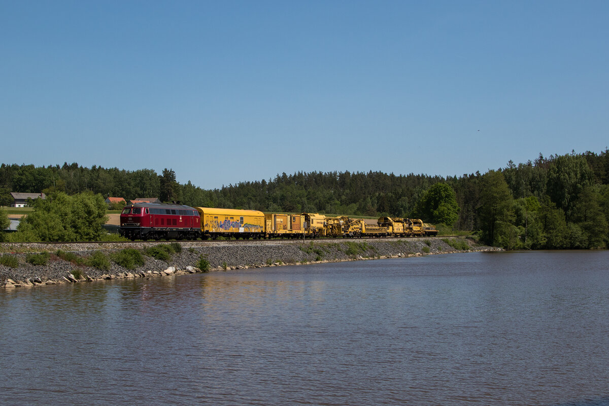 218 155 von  NeSa  war mit einem Bauzug am 29. Mai 2023 am Rechenweiher bei Escheldorf in Richtung Weiden unterwegs..