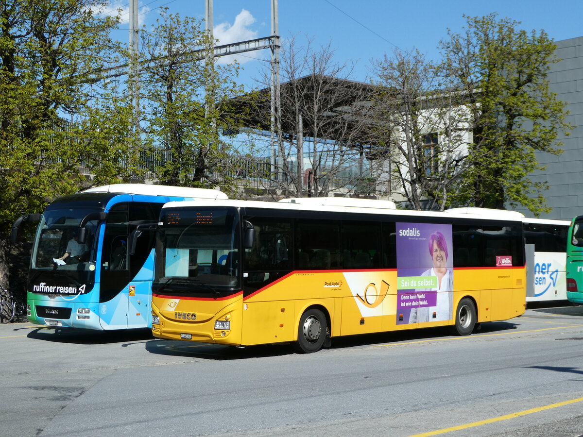 (248'322) - PostAuto Wallis - VS 445'904/PID 10'455 - Iveco am 9. April 2023 beim Bahnhof Brig