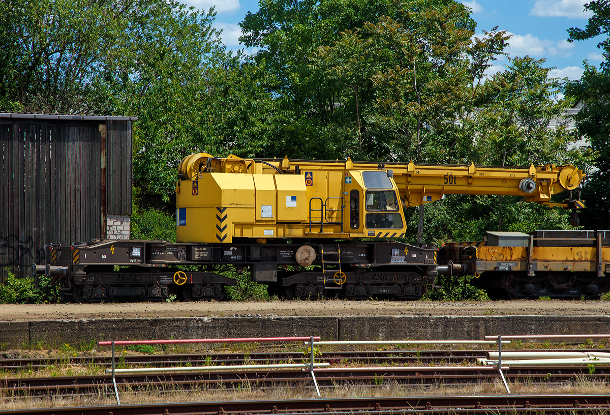 
50t-KIROW-Schienenkran TELVAR 50-1 der Hering Bau (Burbach),  Schweres Nebenfahrzeug Nr. 97 82 35 501 19-1 ist am 30.05.2020 beim Bahnhof Bonn-Beul abegestellt.

Der Eisenbahndrehkran wurde 1992 von der Schwermaschinenbau KIROW Leipzig GmbH  (bis 1990 zum TAKRAF Kombinat) unter der Fabriknummer 1 gebaut. Er war wohl der erste gebaute Kran nach der Reprivatisierung 1990,  bis dahin bestand das TAKRAF Kombinat aus 26 Einzelbetrieben, zu denen auch der VEB Schwermaschinenbau S. M. Kirow Leipzig gehörte.

TECHNISCHE DATEN:
Spurweite: 1.435 mm
Eigengewicht: 120 t
Länge über Puffer: 13.600 mm
Achsanzahl: 6 (in zwei Drehgestellen)
Drehzapfenabstand: 6.000 mm
Achsabstand in den Einzeldrehgestellen: 3.000 mm (2x 1.500 mm)
Treib- und Laufraddurchmesser: 920 mm (neu)
Fahrgeschwindigkeit im Zugverband: 120 km/h
Fahrgeschwindigkeit mit Eigenantrieb: 20 km/h ohne Last 6 km/h mit Last
Zugelassen als Schwerwagen für Streckenklasse: CS04 und höher
kleinster befahrbarer Radius: 80 m
Bremse: KE-GP

Tragfähigkeiten:
bei  8,00 m Ausladung vor Puffer:  50 t, freistehend: 46 t
bei 18,00 m Ausladung vor Puffer: 17 t, freistehend: 46 t
Hubgeschwindigkeit: bis 30 t 5,3m/min, bis 50 t 3,5 m/min
