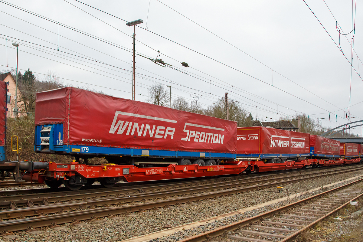 6-achsiger Gelenk-Taschenwagen 31 80 4955 497-1 TEN D-DB der Gattung Sdggmrs 738.1, der DB Schenker Rail Deutschland AG hier mit Stattelauflieger der Spedition Winner, am 12.03.2016 bei der Zugdurchfahrt in Kreuztal. 

Die Wagen werden nach einem Patent der Cattaneo SA (Schweiz) gebaut und sind baugleich zu Wagen von Kombiverkehr, Cemat, der CFL und Wascosa. Mgliche Ladeeinheiten sind, wie hier zwei Trailer oder alternativ bis zu vier Wechselbrcken und/oder Container.

Technische Daten Sdggmrs 738.1:
Spurweite: 1.435 mm
Anzahl der Achsen: 6 (in drei Drehgestellen)
Lnge ber Puffer:  34.200 mm
Drehzapfenabstand:  2  14.200 mm
Aufstandshhe ber SOK fr Container:  1.155  mm
Hchstgeschwindigkeit: 120  km/h (leer und beladen)
Maximales Ladegewicht:  100,0  t
Eigengewicht:  34.580  kg
Drehgestell-Radsatzstand:  1.800  mm
Laufraddurchmesser: 920 mm (neu) / 840 mm (abgenutzt)
Kleinster bef. Gleisbogen:  R = 75  m
Bauart der Bremse:  2  DK-GP-A
Handbremse:  Fbr1)