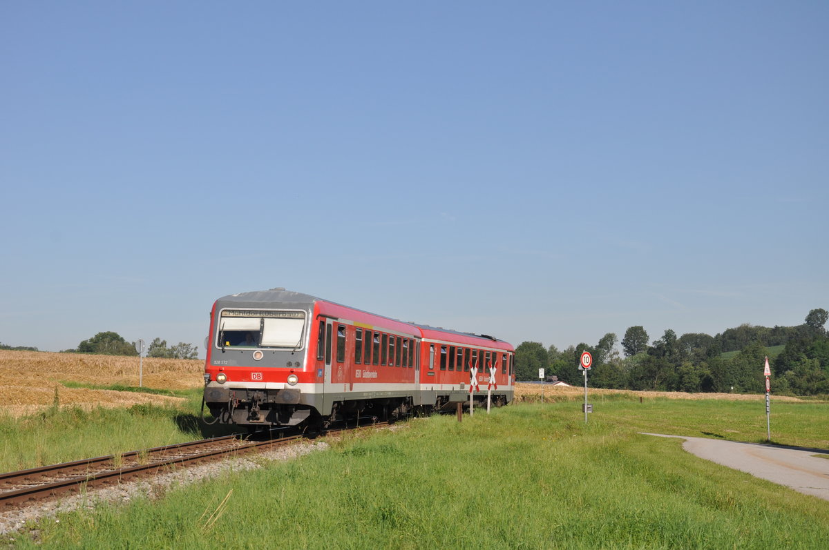 628 572 der Südostbayernbahn war am Morgen des 10. Juli 2020 als RB 29412 nach Pocking unterwegs und wurde dabei kurz nach einem unbeschrankten Bahnübergang im kleinen Örtchen Wallham fotografiert. 