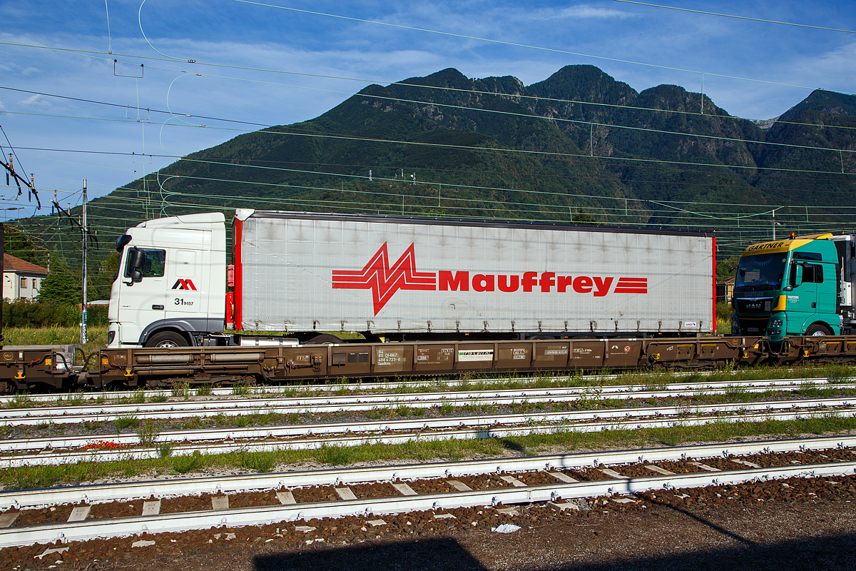 8-achsiger Niederflurwagen Rollende Landstrae der Gattung Saadkms, 84 85 4984 723-6 CH-RALP der RAlpin AG, am 02.08.2019 im Zugverband in Domodossola, in Richtung Simplon fahrend.

Das Fahrzeug ist fr den Transport von Last- und Sattelzgen im begleiteten Verkehr, einer Form des kombinierten Ladungsverkehrs, vorgesehen und kommt in alpenquerenden Shuttlerelationen zum Einsatz. Dabei fahren Lastkraftwagen in speziellen Terminals direkt von der Strae ber eine Rampe auf den Wagen, um vom Ausgangsort zum Ziel transportiert zu werden. Der Fahrer zieht sich in einen speziellen Begleitwagen mit Liegeabteilen zurck, fhrt am Zielort weiter und liefert die Ware sicher beim Kunden ab. Diese Form des kombinierten Verkehrs von Schiene und Strae – Rollende Landstrae (ROLA) – gewinnt, nicht zuletzt aufgrund von gesteigertem Verkehrsaufkommen und Umweltbewusstsein, immer mehr an Bedeutung.

Auch in Deutschland (in Nordrhein-Westfalen) denkt man ber Rola-Zge nach, der Grund liegt aber darin, dass eine Talbrcke der Autobahn A 45 im Raum Ldenscheid nicht mehr befahrbar ist. Ein Neubau dauert bekanntlich Jahre, so bleibt auf Jahre hin die Umleitungsstecke ber Landstraen (durch Ldenscheid) berlastet.

Die letztentwickelte Version der Wagen ermglicht eine Zuladung von 44 t sowie mit ihrer nochmals minimierten Hhe der Ladeflche den Transport von Sattelanhngern bis 4 m Eckhhe auf der St. Gotthard – Achse.

TECHNISCHE DATEN:
Hersteller: Talbot, Aachen
Spurweite: 1.435 mm
Anzahl der Achsen: 8 (in 2 Drehgestellen)
Lnge ber Puffer: 19.995 mm (mit Kopfstck) / 19.590 mm (ohne Kopfstck)
Drehzapfenabstand: 13.700 mm
Achsabstand in den Drehgestellen: 750 / 700 / 750 mm
Laufkreisdurchmesser: 380 (neu) / 355 mm (abgenutzt)
Radsatzlager: TAROL100/175 (Kegelrollenlagereinheiten)
Ladelnge: 18.600 mm (mit Kopfstck) / 19.000 mm (ohne Kopfstck)
Eigengewicht: 18.500 kg
Max. Zuladung: (S) 44,0 t ab Streckenklasse A
Zul. Geschwindigkeit: 100 km/h
Kleinster bef. Gleisbogenradius: R 150 m (R 80 m als Einzel Wagen)
Bauart der Bremse: Freno O-GP-A 
Drehgestell-Bauart: gummigefedert BA 690 (Talbot RoLa)