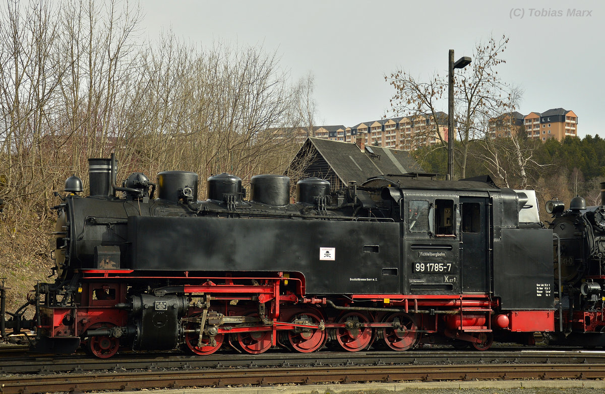 99 1785-7 wurde 1954 vom Lokomotivbau Karl-Marx in Babelsberg gebaut. Sie zählt zu den 24 DR-Neubaulokomotiven, die für die Schmalspurbahnen der Spurweite 750mm gebaut wurden. Von den 24 Neubaulokomotiven sind heute noch 22 erhalten. Diese Lokomotiven werden unter der Baureihe 99.77-99.79 gezählt. 
Hier ist die 99 1785-7 auf dem Bahnhof Oberwiesenthal am 30.03.2016 zusehen. Sie wurde mit 99 1741-0 und 99 1772-5 über den Bahnhof rangiert.