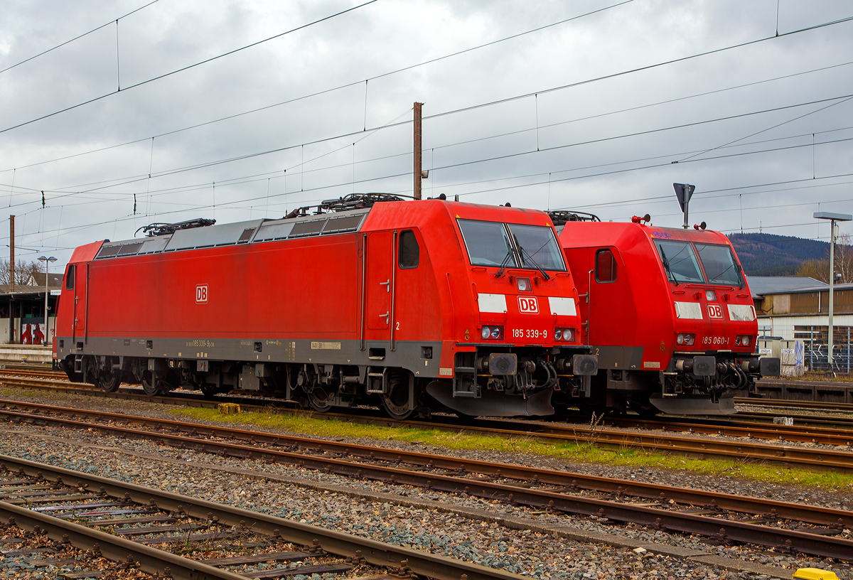 Abgestellt in Kreuztal am 13.03.2020:
Die 185 339-9 (91 80 6185 339-9 D-DB) eine Bombardier TRAXX F140 AC2 (Fabriknummer 34221 Baujahr 2008) und die 185 060-1 (91 80 6185 060-1 D-DB) eine Bombardier TRAXX F140 AC1 (Fabriknummer 33469 Baujahr 2002), beide von der DB Cargo AG.

Hier sieht am gut den optischen Unterschied zwischen der TRAXX F140 AC2 (Baureihe 185.2) und der Vorgängerversion der TRAXX F140 AC1 (Baureihe 185.0). Man sieht es neben den Puffern deutlich, die Ausklinkung und die Trittstufen. Die Griffstangen sind bei der BR 185.2 eingelassen und bis zur OK Tür hochgezogen. Zudem gibt es vorne beim Rangiertritt zusätzliche Griffstangen. 

Die TRAXX 2 ist eine Weiterentwicklung der Traxx-Baureihen, gegenüber welchen sie als augenfälligste Änderung einen überarbeiteten Lokkasten besitzt. Die Änderung erfolgte um den neuen, strengeren Sicherheitsnormen bezüglich Crashfestigkeit zu genügen und ist an leicht nach unten gezogenen Ecken am Lokkasten und den Frontklappen zum Ausbau der Klimaanlage zu erkennen. Geändert wurde auch die Umrichteranlage.
