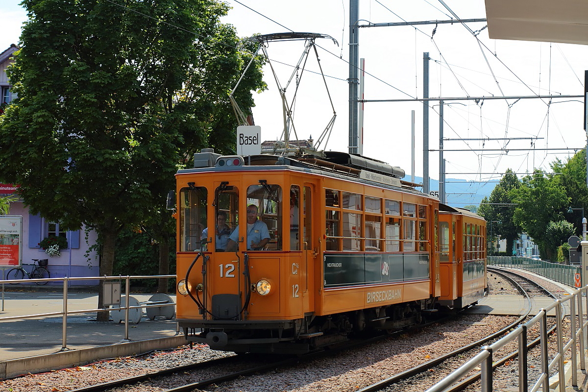 Am 08.08.2015 fährt der Museums-Ce 2/4 12 der Birseckbahn durch Oberwil in Richtung Zentrum. Ein Zufallstreffer, deshalb nicht an einem optimalen Fotostandpunkt und leider auch im Gegenlicht.