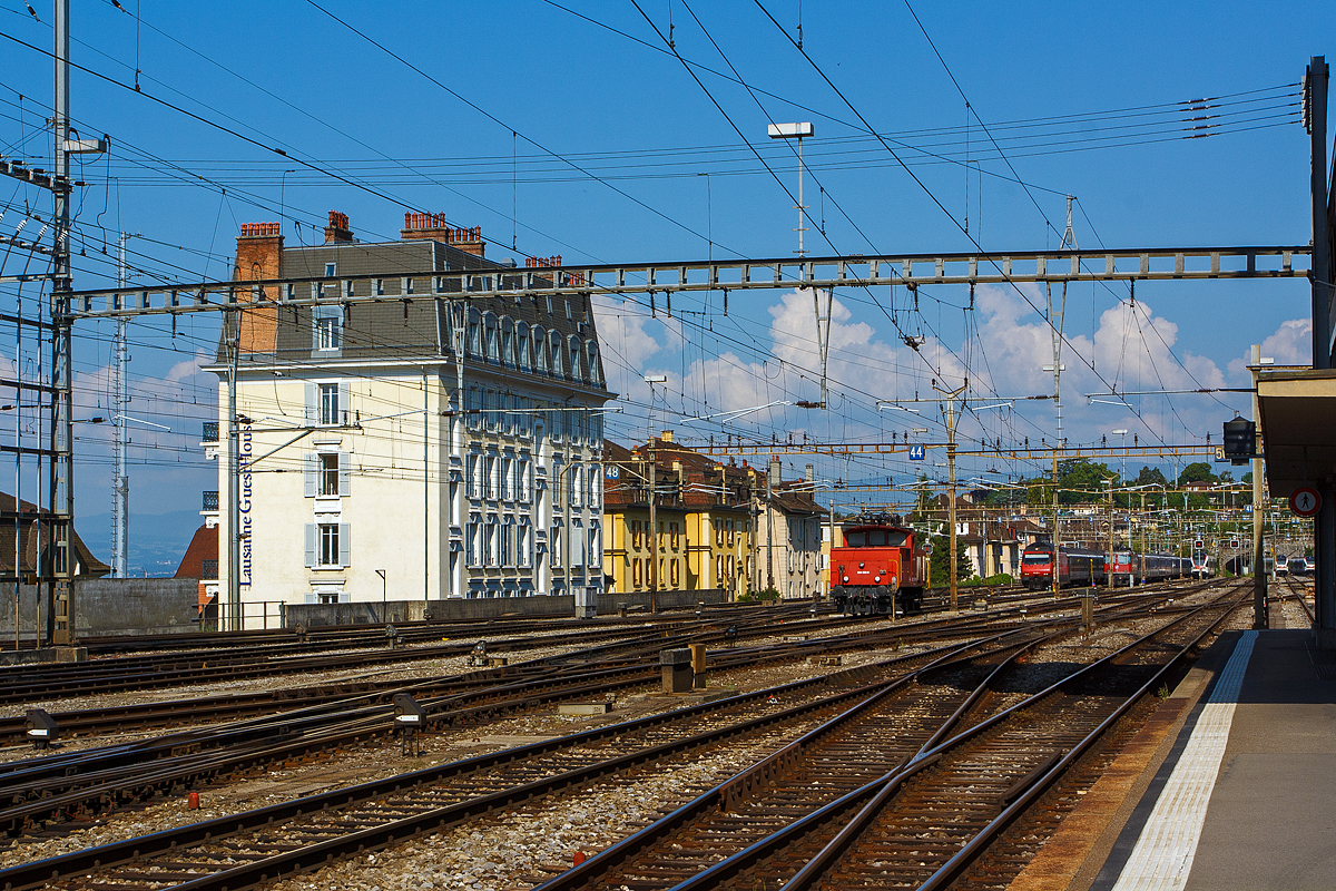 Am 29.05.2012 am Bahnhof Lausanne, halbrechts steht die SBB Ee 934 553-0 (ex Ee 3/3 IV - 16 553), rechts weiter hinten ein paar Abstellgruppen. 

Die Ee 3/3 IV ist eine 4-Stromsystem-Lok (15 kV 16,7 Hz AC, 25 kV 50 Hz AC, 3 kV DC und 1,5 kV DC), diese komplizierte Technik erforderte höhere und breitere Aufbauten vor und hinter dem Führerstand und führte zu niedrigerer Leistung (390 kW / 530 PS). Zugleich konnte dank des moderneren Kuppelstangenantriebs die Höchstgeschwindigkeit auf 60 km/h angehoben werden. Insgesamt wurden 10 dieser Loks 1962-1963 bei SLM/SAAS gebaut.