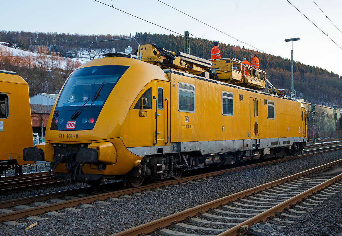 
Am frühen Morgen des 13.02.2018 hatte ein Lkw alle vier Oberleitungen am Bahnübergang Charlottenhütte (an der Siegstrecke) in Niederschelden beschädigt. Die Bahnstrecke zwischen Siegen und Brachbach war den ganzen Tag gesperrt, für diesen Notfall waren zwei Turmtriebwagen bzw. Instandhaltungsfahrzeuge für Oberleitungsanlagen (IFO) der DB Netz AG den ganzen Tag dort für die Reparaturarbeiten im Einsatz.

Hier das Instandhaltungsfahrzeug für Oberleitungsanlagen (IFO) 711 104-0 der der DB Netz AG.

Das IFO 711 104-0 wurde 2002 von der GBM Gleisbaumechanik Brandenburg/H. unter der Fabriknummer  711.104 gebaut. Der ORT 708 325-6 wurde 1990 von der Waggonbau Görlitz unter der Fabriknummer 20300/9 und als 188 325-5 an die DR geliefert.

Das Instandhaltungsfahrzeug für Oberleitungsanlagen (IFO) 711 104-0 ist ein Fahrzeug der Baureihe 711.1, sie werden auch als Hubarbeitsbühnen-Instandhaltungsfahrzeug-Oberleitungsanlagen (HIOB) bezeichnet. Die Fahrzeuge werden auch auf Schnellfahrstrecken eingesetzt. Diese Baureihe ist moderner und schneller als die Baureihe 711.0. Die Fahrzeuge werden bei der Behebung von Schäden und zur planmäßigen Instandhaltungen im Bereich der Oberleitungsanlagen, Brücken und Tunnel eingesetzt. Es wurden zwischen 2002 und 2004 insgesamt 23 Fahrzeuge dieses Typs von der Gleisbaumechanik Brandenburg hergestellt. Das Hubarbeitsbühnen-Instandhaltungsfahrzeug für Oberleitungsanlagen der Baureihe 711.1 ist ein vierachsiges Schienenfahrzeug in Regelbauart. Die Höchstgeschwindigkeit beträgt in Eigenfahrt 160 km/h, zudem ist es auch für Steilstrecken (bis 68 ‰) zugelassen.

Als Streckenfahrantrieb steht eine 2-Motorenanlage mit einer Leistung von insgesamt 1176 kW (2 x 588 kW) zur Verfügung. Die Leistungsübertragung übernehmen hydro-dynamische Getriebe.

Für den Arbeitseinsatz ist ein weiterer kleinerer Dieselmotor mit 130 kW Leistung installiert. Dieser Motor arbeitet ausschließlich im Zusammenhang mit einem Russpartikelfiltersystem.

Mit Hilfe des Arbeitsantriebes werden alle hydraulischen Antriebe versorgt einschließlich des hydrostatischen Fahrantriebes für Arbeitsfahrt. Das Laufwerk des Fahrzeuges besteht aus zwei angetriebenen Drehgestellen (alle Radsätze angetrieben). Die Radsätze sind mit jeweils 2 Scheibenbremsen ausgerüstet. Für optimale Ausnutzung der Reibungsverhältnisse sorgen eine Gleit- und Schleuderschutzanlage sowie eine Sandstreuanlage.

Das Fahrzeug besitzt eine durchgehende indirekt, selbsttätige, mehrlösig, wirkende Druckluftscheibenbremse der Bauart KE, zwei hydrodynamische Bremsen / Retarder, eine direkt wirkende Druckluftbremse als Zusatzbremse, eine direkt wirkende elektro-pneumatische Bremse, eine Magnetschienenbremse, eine Federspeicherbremse als Feststellbremse.

Aufbau und Innenraum
Der Aufbau ist in drei Teile gegliedert. An den beiden Enden befinden sich die Kopfsegmente mit den Führerständen, diese sind Zulieferteile der Fahrzeugtechnik Dessau und entsprechen in der Form dem ehemaligen Innovationszug der DB Regio. Zwischen den Kopfsegmenten ist der Wagenkasten mit einer Werkstatt, einem Lagerraum, einer Nasszelle und einem Sozialraum mit einem Arbeitsplatz. Die Werkstatt beinhaltet alle gebräuchlichen Ersatzteile und Werkzeuge zur Instandhaltung und Reparatur an Oberleitungsanlagen, im Werkstattbereich befindet sich dann auch die Nasszelle mit Waschmöglichkeit und Toilette. Die Toilette ist ausgerüstet mit einem Bioreaktor, welcher das Abwasser reinigt und nur noch heißes Wasser an die Umwelt gelangen lässt – der Feststoffbehälter muss nur zur planmäßigen Instandhaltung in einem Ausbesserungswerk entleert werden.

Es folgt der Videoarbeitsplatz mit Monitor zur Beobachtung der Fahrdrahtlage per Kameras, einem Faxgerät und einem Bedienfeld zum Schwenken der Kamera und des Dachscheinwerfers. Gegenüber dem Videoarbeitsplatz befindet sich eine kleine Küchenzeile mit Mikrowelle, Wasserkocher, Kaffeemaschine, Schränken, Trinkwasserbehälter und einem Abwaschbecken.

Vorbei an der Hydraulik für die freischwenkbare Hubarbeitsbühne gelangt man in den Aufenthaltsraum mit Radio, Sitzgelegenheiten, einem Tisch und Trockenschränken für Kleidungsstücke, hieran schließt durch eine Tür abgetrennt der zweite Führerstand an.

Dachausrüstung
Auf dem Dach sind zwei Hubarbeitsbühnen vorhanden, eine als freischwenkbare (Palfinger PA 360) und eine als nur in der horizontalen Richtung zu bewegende (Palfinger PA 90), beide können gekuppelt und somit die Nutzfläche vergrößert werden. Es wurden auf dem Dach außerdem ein Seildrücker und ein Stromabnehmer mit einstellbarer Anpresskraft, Videoüberwachung sowie diverse Beleuchtungskörper installiert. Die freischwenkbare Hubarbeitsbühne PA 360 hat einen Arbeitskorb mit 1.500 mm × 1.600 mm Abmessung und kann 18,5 m über SO und etwa 10 m unter SO erreichen. Die Hubarbeitsbühne PA 90 besitzt die Abmessungen 3.500 mm × 1.600 mm, erreicht 6 m über SO und kann zu beiden Seiten um 90 Grad gedreht werden.

Beide Bühnen können über eine Gegengleissperre gesichert werden, um nicht aus Versehen in den lichten Raum des Gegengleises zu drehen.

Zur Instandhaltungsausrüstung des Fahrzeuges gehören:
1 Freischwenkbare Hubarbeitsbühne, 
1 Hubarbeitsbühne mit schwenkbarem Arbeitskorb,
1 Fahrdraht- und Tragseildrücker,
1 Stromabnehmer mit Messlineal und einstellbarer Anpresskraft,
1 Messsystem für ein- und auslaufende Kettenwerke,
1 Videoanlage zur Beobachtung des Stromabnehmers.
Alle Funktionen des Fahrzeuges werden mittels einer Fahrzeugsteuerung gesteuert und überwacht.

Elektrische Ausrüstung
Die Fahrzeuge besitzen eine komplexe elektrische Ausrüstung, die über eine Speicherprogrammierbare Steuerung (SPS) so gut wie alle Fahrzeugfunktionen überwacht und ausführt. Auf diese Art wird eine Fehlbedienung weitestgehend ausgeschlossen, sicherheitsrelevante Einstellungen werden zuverlässig eingehalten. So ist es zum Beispiel durch die SPS nicht möglich, mit eingelegter Federblockierung schneller als 15 km/h zu fahren. Wenn sich ein Dachgerät wie Arbeitsbühne oder Seildrücker nicht in Transportstellung befindet, ist es nicht möglich in die Streckenfahrt überzugehen. Außerdem kann ein „Einmotorbetrieb“ genutzt werden, bei dem die Wahl zwischen dem Fahrmotor 1 oder 2 besteht oder der Motor mit den wenigsten Betriebsstunden genutzt wird. Auch die Außenbeleuchtung (Dreilicht-Spitzensignal und Arbeitsfeldbeleuchtung) werden per SP-Steuerung gesteuert.

Obligatorisch ist die Ausrüstung mit einer Indusi der Bauart Siemens I 60R in der Softwareversion PZB 90 V2.01. Es gibt zwei Zeit/Zeit-Sicherheitsfahrschaltungen, eine software-basierende für die Arbeitsfahrt und eine hardware-basierende für die Streckenfahrt. Weiterhin dient ein GSM-R Zugfunkgerät der Verständigung mit angeschlossenen Stellen. 

TECHNISCHE DATEN:
Spurweite: 1.435 mm (Normalspur)
Achsformel:  B'B'
Länge über Puffer: 24.640 mm
Drehzapfenabstand: 17.000 mm
Achsabstand in den Drehgestellen: 2.600 mm
Breite: 2.875 mm
Höhe: 4.650 mm
Raddurchmesser: 920 mm (neu) / 860 mm (abgenutzt)
kleinster befahrbarer Gleisbogen: R= 150 m
Leergewicht: 78,7 t
Nutzlast: 	 5,2 t
Dienstgewicht: 84 t
Zur Mitfahrt zugel. Personenzahl: 9
Höchstgeschwindigkeit: 160 km/h / geschleppt 120km/h / Arbeitsfahrt 10 km/h
Anfahrzugkraft: 64 kN

Antrieb 	 
Fahrmotor: zwei Dieselmotoren vom Typ MAN D2842 LE602, EURO 2 mit je 588 kW Leistung
Max. Drehzahl: 2.100 U/min
Max. Drehmoment: 	3.200 Nm bei 1.300-1.600 U/min

Arbeitsmotor: ein Dieselmotor vom Typ MAN D0826 LOH 19, EURO 2 mit 130 kW Leistung
Max. Drehzahl: 1.500 U/min
Max. Drehmoment 	825 Nm bei 1.700 U/min

Getriebe: 	Voith-Turbogetriebe T311 bre;
