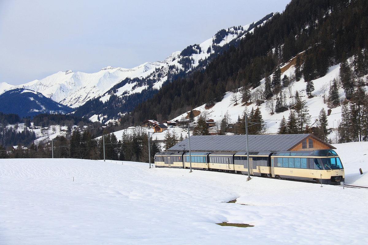 An diesem Tag leuchteten die Schneeberge der Freiburger Alpen besonders weiss. Durchfahrt des MOB Zuges mit Triebwagen ABe4/4 9302 - Bs 251 - BD 204 - Bs 237 - Ast 151 nach Gruben und Gstaad hinunter. 4.Februiar 2021