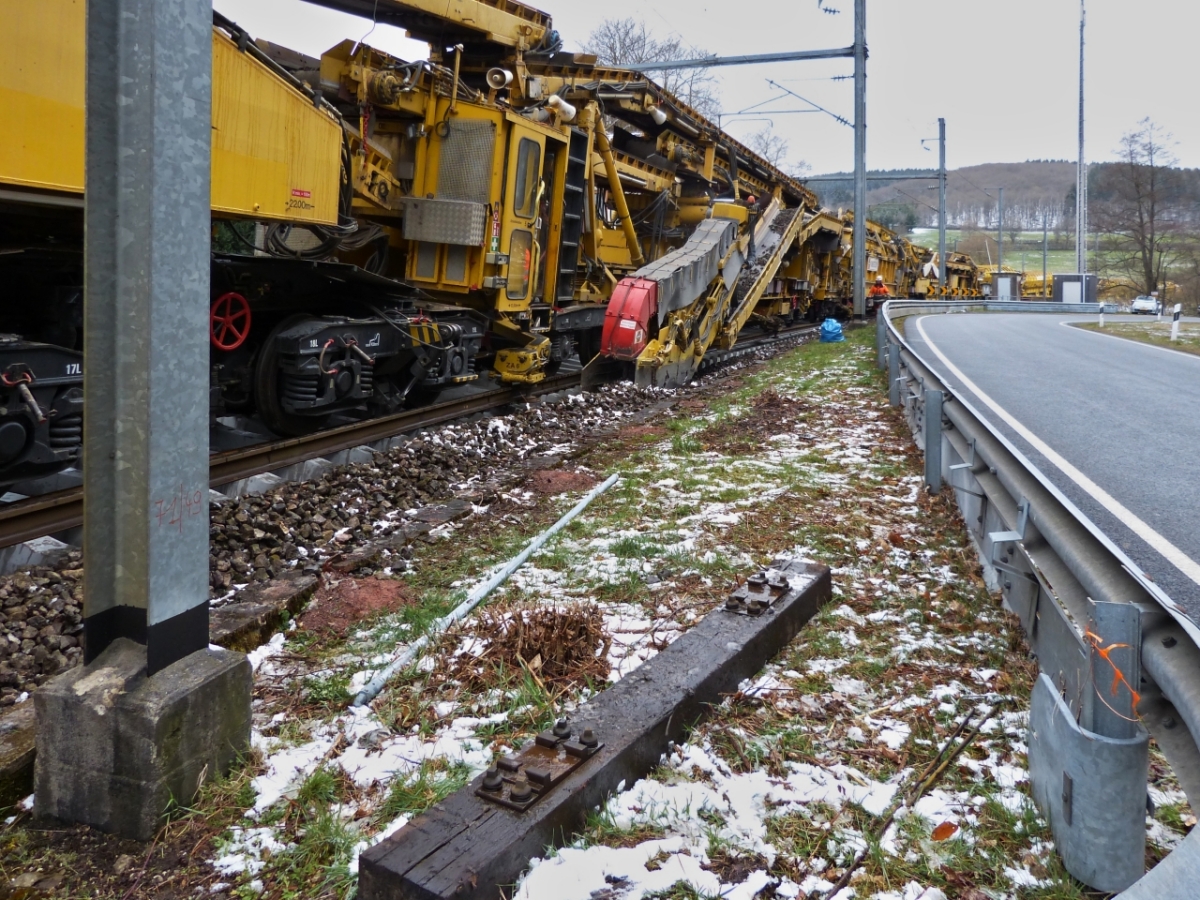 An einer Straenkurve neben der Bahnstrecke nahe Drauffelt, gelangen mir einige Bilder der Arbeitsweise des Gleisumbauzuges. Ein weiteres Transportband befrdert den alten Schotter  der vom Schild unter der Maschine an die Seiten gedrckt wurde zum Zentralfrderband entsorgen des Schotters in die Siloeinheiten. 07.04.2021