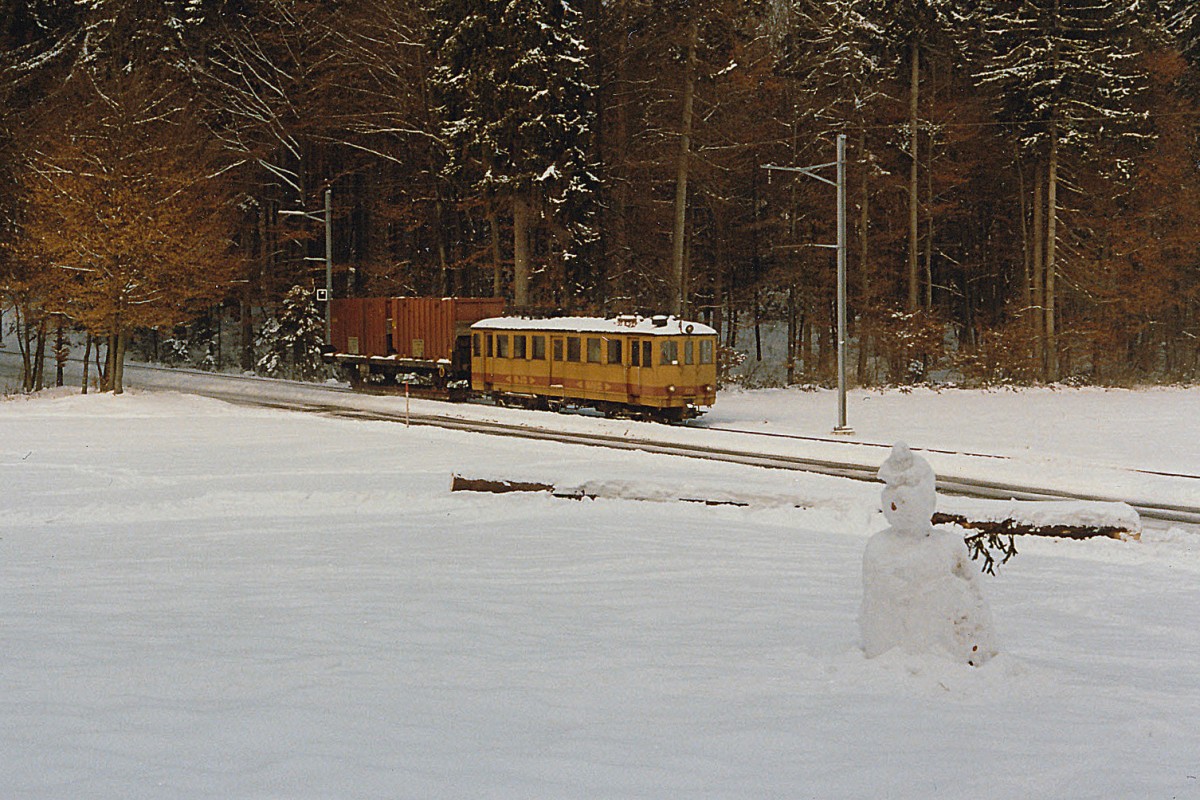 ASm/OJB: Kehrichtzug Langenthal-Niederbipp mit De 4/4 122 ex LMB CFe 4/4 Nr 6 (1917) bei Bannwil  mit Schneemann  im Dezember 1985. Damals wurde der Kehricht noch von der Verladestation Langenthal mit Normalbahngterwagen auf Schmalspur-Rollschemel zum SBB-Bahnhof Niederbipp transportiert, wo die Kehrichtwagen von einem SBB-Gterzug bernommen wurden, der sie nach Solothurn-HB brachte. Heute werden die Kehrichtwagen nur noch auf einem kurzen Schmalspur-Streckenabschnitt auf Rollbcken von der KEBAG-Verladestation zur ASm-Rollbockanlage Langenthal transportiert. Im September 1992 wurde der De 4/4 122 abgebrochen. Foto: Walter Ruetsch