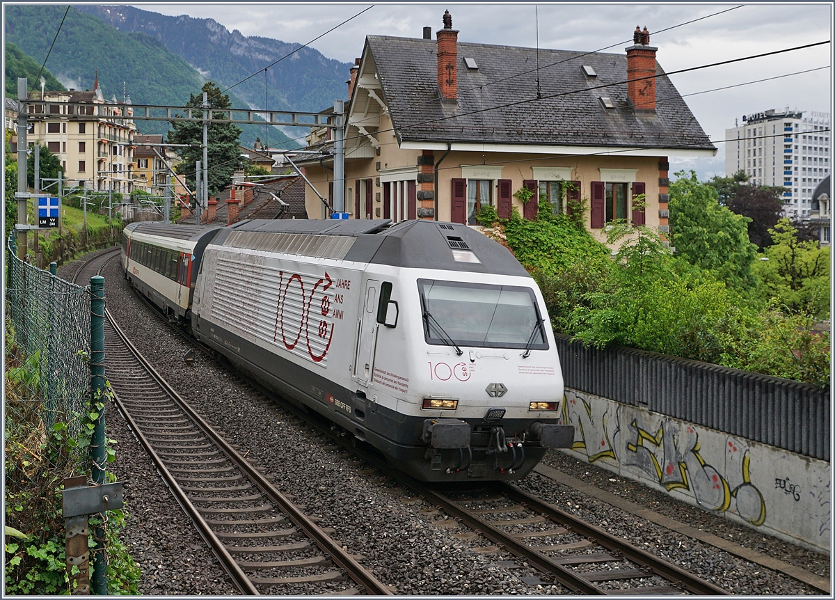 Auch wenn die Hotelgäste ihre Zimmer zum See hin haben, und auf dieser Seite oft nur das Personal haust, bietet sich auch hier der eine oder andere reizende Blick: Die SBB Re 460 113-4  100 Jahre SEV  fährt mit ihrem IR90 nach Genève Aéroport kurz nach der Abfahrt in Montreux an einem schmucken Haus vorbei.

5. Mai 2020