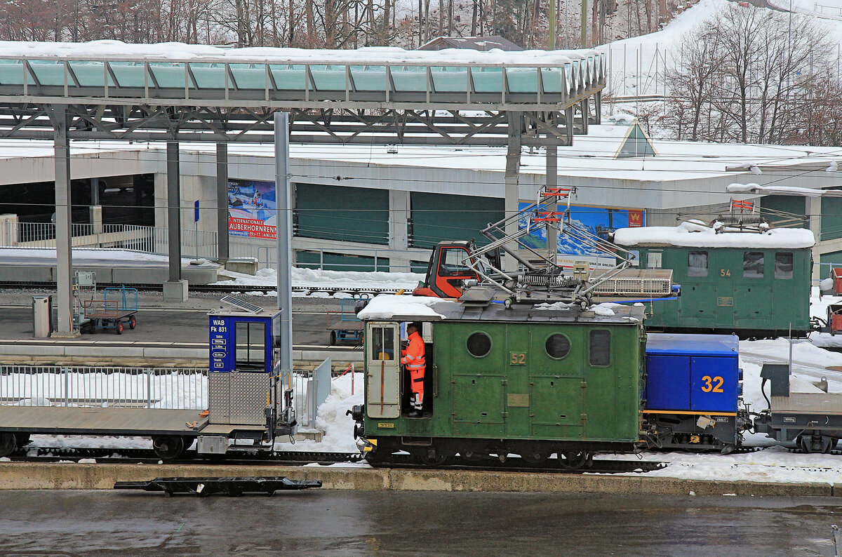  Aus dem Leben der Wengernalpbahn Lok 54 : Jetzt überlässt die Lok die Rangieraufgaben der Schwesterlok 52 und wartet still und schneebedeckt im Hintergrund, Lauterbrunnen, 14.Dezember 2020 