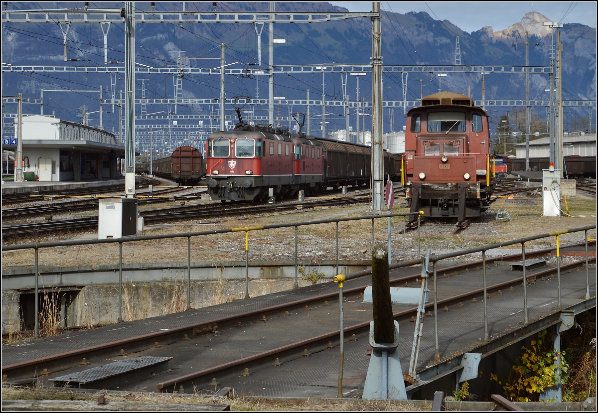 Ausfahrt eines Güterzuges mit Re 4/4<sup>II</sup> 11190 und der Re 4/4<sup>III</sup> 11351. Rechts steht Em 3/3 18838 und im Hintergrund leuchtet der Hohe Kasten vor sich hin. Buchs, November 2015.