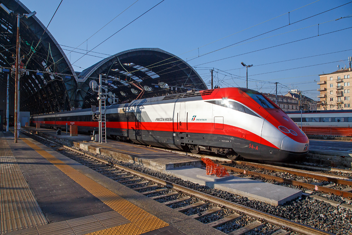 
Ausfahrt eines sehr langen  Frecciarossa  (deutsch: roter Pfeil) der Trenitalia (100-prozentige Tochtergesellschaft der Ferrovie dello Stato) am 29.12.2015 vom Bahnhof Milano Centrale (Mailand Zentral). Der Frecciarossa ist eine Zuggattung für Züge mit einer Höchstgeschwindigkeit von 300 km/h. Hier ist es der ETR 500 - 56 ein ETR 500 der 2.Serie. ETR steht ElettroTreno Rapido.

Diese Züge bestehen aus zwei Triebköpfen vom Typ E.404B und aus zwölf Mittelwagen, ETR 500.31 bis 60 komplett der 2.Serie. Bei den ETR 500.01 bis 30 sind nur die beiden Triebköpfe aus der 2.Serie, die Mittelwagen dagegen stammen aus der 1.Serie der ETR 500 (Mono). 

Durch die begrenzte Stromstärke des Gleichstromnetzes können die Hochgeschwindigkeitszüge nur für Geschwindigkeiten bis zu 250 km/h ausreichend mit Energie versorgt werden. Deshalb entschied sich die italienische Staatsbahn in den 1990er Jahren, weitere Neubau-Schnellfahrstrecken mit Wechselstrom (25 kV, 50 Hz) zu betreiben.

Da die erste Serie der ETR 500 nur für das Gleichstromnetz geeignet ist, wurde ab 1996 eine zweite Serie ETR 500 bestellt und geliefert, die sowohl im Gleichstrom- als auch im Wechselstromnetz fahren kann. Die Zweisystem-Fahrzeuge werden Politensione (deutsch: Mehr-Spannung) genannt. Es gab auch mal zwischenzeitlich Dreisystem-Fahrzeuge (ETR 500 F), die auch unter 1.5 kV DC fahren konnten, diese wurden aber wieder zurückgebaut. Diese waren für den Verkehr nach Frankreich gedacht, bekamen aber dort keine Zulassung.

Die zulässige Höchstgeschwindigkeit der ETR 500 der zweiten Serie von 300 km/h wird im regulären Betrieb aber nur mit Wechselstrom auf neueren Schnellfahrstrecken Italiens erreicht.

Im Gegensatz zur ersten Serie werden bei der zweiten Serie Einholmstromabnehmer verwendet. Die Triebköpfe verfügen jeweils über einen Abnehmer für Gleichstrom und einen Abnehmer für Wechselstrom. Äußerlich unterscheiden sich die beiden Bauserien durch starke Unterschiede des „Gesichts“. Die Front der zweiten Serie wurde aufgelockert und rundlicher gestaltet, besonders betont durch die getrennt angeordneten Spitzensignale, während die Frontscheiben kleiner und rechteckig ausgeführt wurden. Wobei ja die Triebköpfe (E.404A) der ersten Serie zu Lokomotiven der Baureihe E.414 umgebaut wurden.


TECHNISCHE DATEN:
Von einem Triebkopf E.404B
Spurweite: 	1.435 mm (Normalspur)
Achsformel: Bo'Bo'
Länge: 20.250 mm
Höhe: 4.000 mm
Breite: 3.020 mm
Drehzapfenabstand:  11.450 mm
Achsabstand im Drehgestell: 3.000 mm
Dienstgewicht: 68 t
Höchstgeschwindigkeit: 300 km/h
Dauerleistung: 4.400 kW (4 x 1.100 kW) pro Triebkopf
Treibraddurchmesser: 	1.100 mm
Stromsysteme: 3000 V DC und 25 kV 50 Hz AC

Daten der Mittelwagen:
Länge: 26.100 mm
Drehzapfenabstand:  19.000 mm
Achsabstand im Drehgestell: 3.000 mm
Eigengewicht: 40 t

Gesamtzug Daten:
Achsformel: Bo'Bo' (12x 2'2') Bo'Bo'
Gesamtzuglänge: 353.700 mm (bei 12 Mittelwagen)
Gesamteigengewicht: 616 t
Dauerleistung: 8.800 kW
Anfahrzugkraft: 	400 kN
