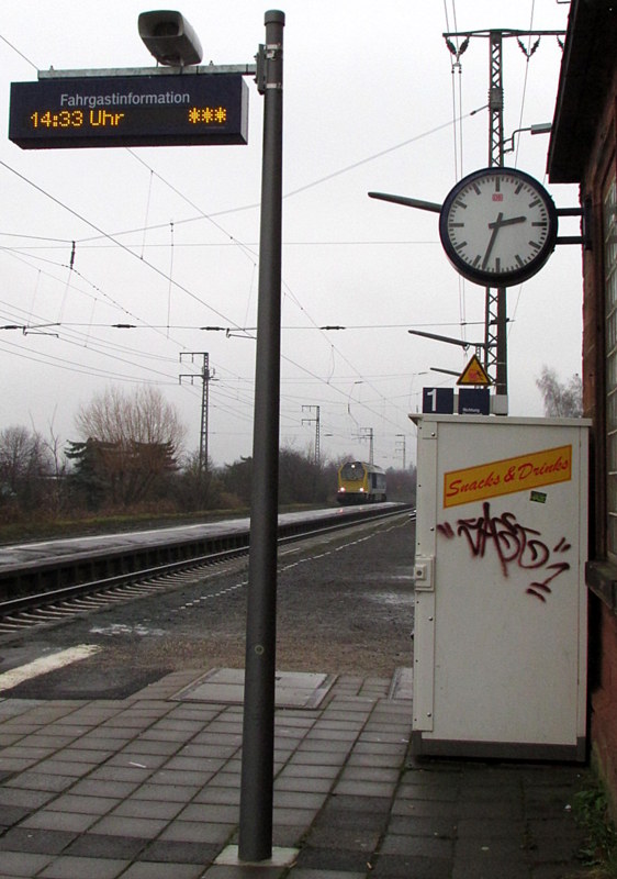 Bahnhofsuhr,Fahrgastinformation und eine Diesellok auf einem Bild.
Aufgenommen in Weiterstadt am 14.Dez.2013 um 14:33 Uhr.