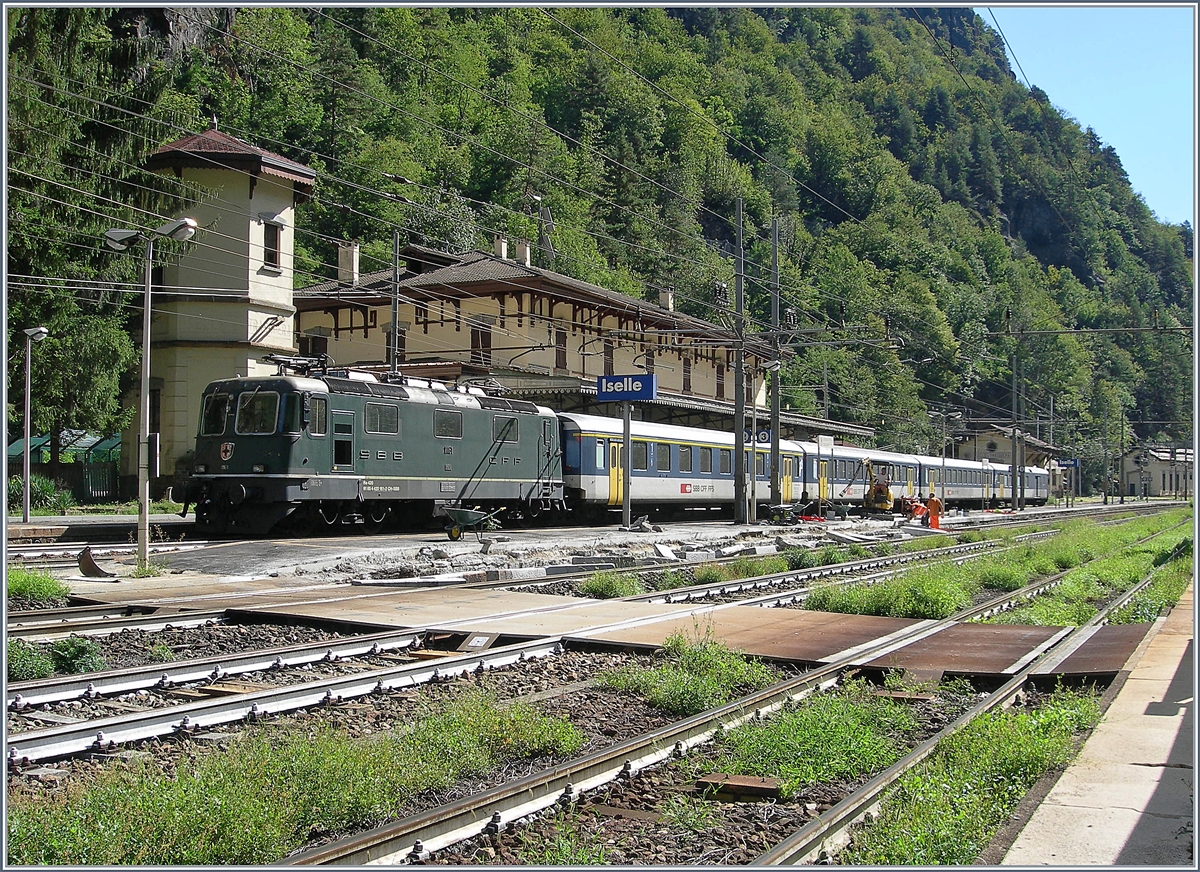 Baubedingte Sperrung der Simplonstrecke zwischen Iselle und Domodossola: Die SBB Re 4/4 II 11161 wartet mit ihrem IR 3220 in Iselle auf die Abfahrt nach Brig. Der Zug besteht aus folgenden Reisezugwagen: A 50 85 18 35 028-1, B 5085 20 35 265-1, B 50 85 20 316-2 und dem BDt 50 85 82 33 923-2. Das Bild entstand, indem ich meinen kleinen Fotoapparat (Coolpix 7900) durch den Gitterzaun schob und dann abdrückte.

19. August 2020