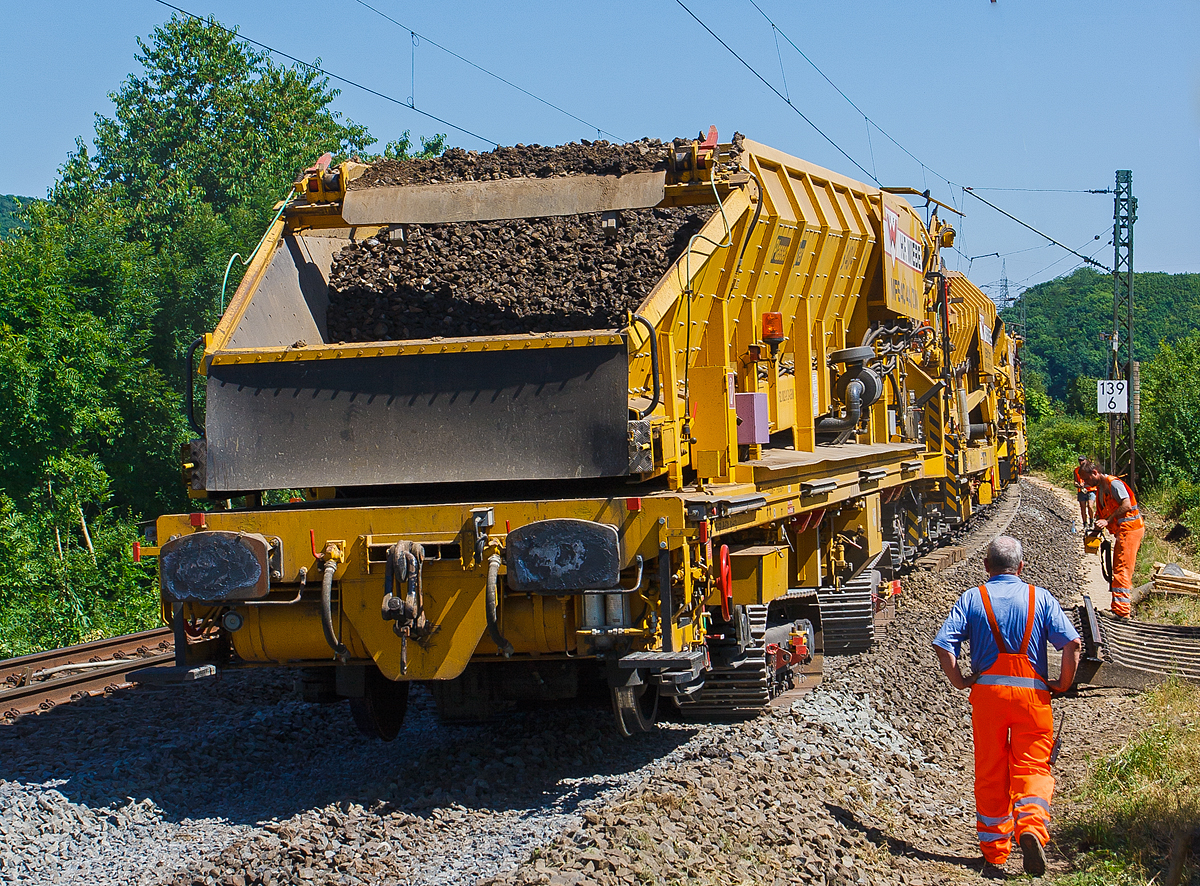 Baustelle im Bahnhof Katzenfurt (Lahn-Dill-Kreis) am 20.07.2013: Der MFS 40/4-A-ZW der H. F. Wiebe, Schweres Nebenfahrzeug 99 80 9052 002-9 D-GBM (ex 97 19 13 502 57-3) übergibt den Aushub an eine, auf dem noch vorhandenen Gleis stehenden, gleisgebundenen Materialförder- und Siloeinheit MFS 250 (H.F. Wiebe Bezeichnung Bunker-Schüttgut-Wagen BSW 11000).