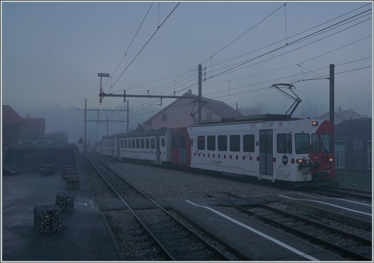 Bei dichtem Nebel und noch in der Morgendämmerung erreicht der TPF Be 4/4 121 mit dem B 207, B209 und dem ABt 221 den Bahnhof von Broc Village. Der Zug ist als RER 60 14954 von Bulle nach Broc Farbrique unterwegs. . Ab nächstem Jahr soll die Strecke von Bulle nach Broc Farbrique auf Normalspur umgebaut werden.


26. Nov. 2020