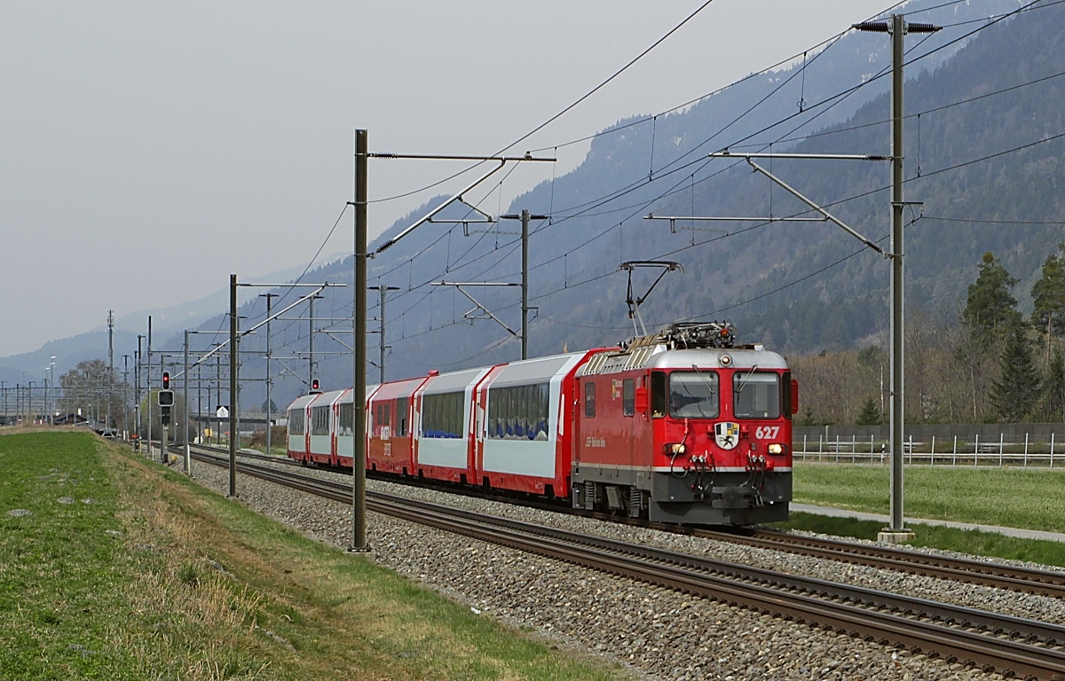 Bei Felsberg befördert die Ge 4/4 II 627  Reichenau-Tamins  am 29.03.2022 den Glacier-Express nach Chur