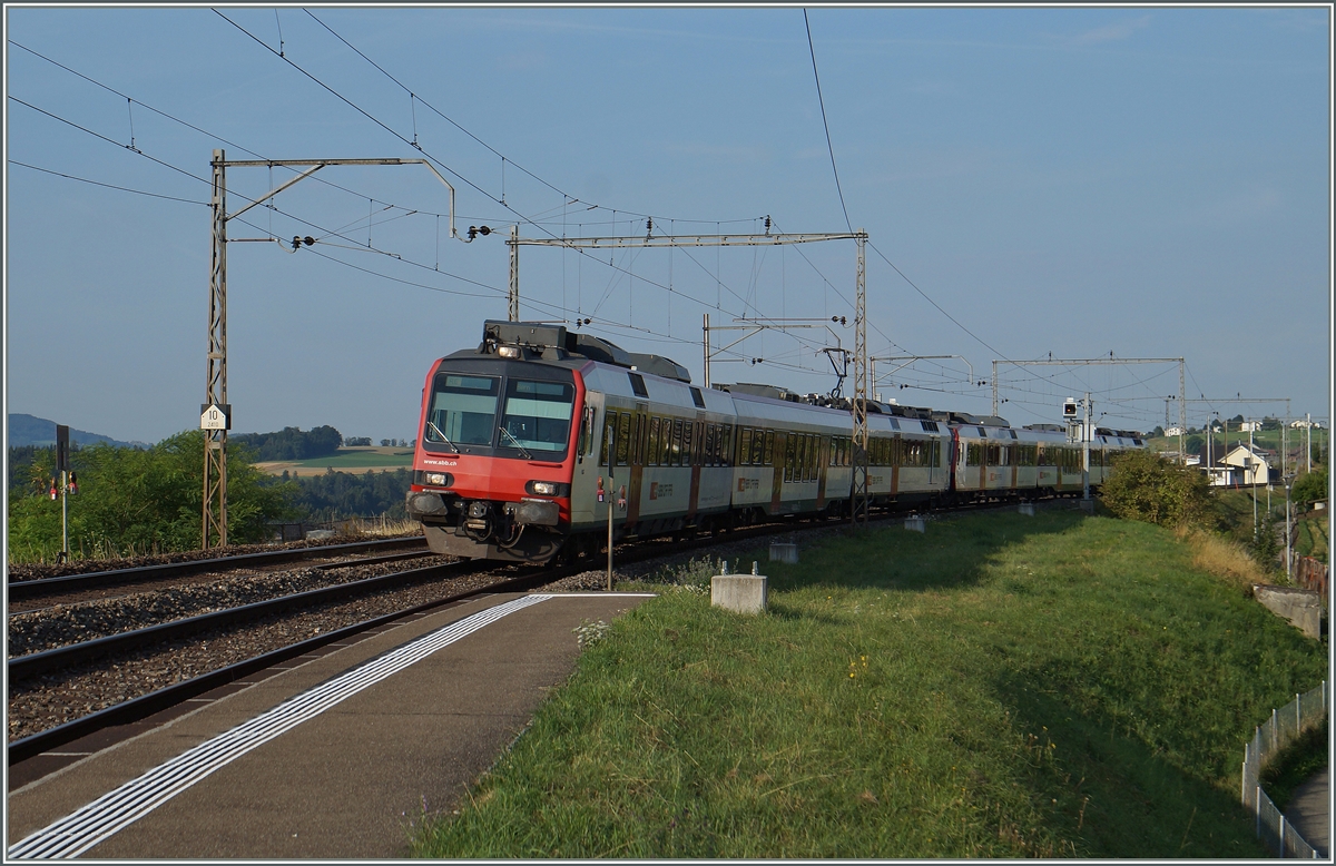 Bei Neyruz und im weiteren Streckenverlauf Richtung Rosé stehen wohl noch die letzten alten, aber sehr filigranen Fahrleitungsmaste zwischen Genève und St.Gallen.
Ein RE Palézieux/Bulle - Romont - Bern erreicht Neyruz, fährt hier jedoch ohne Halt durch. 6. August 2015