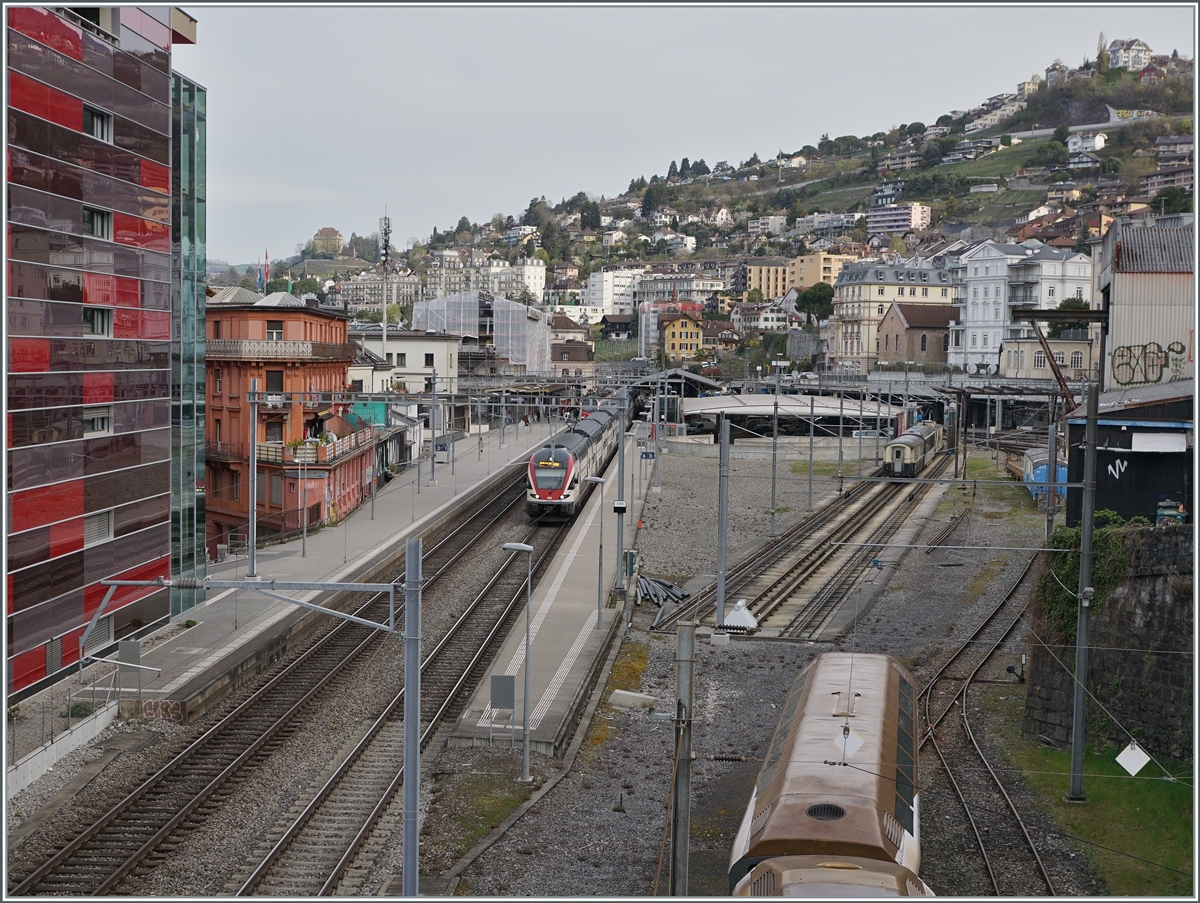 Blick auf den Bahnhof von Montreux mit eine dort auf die baldige Abfahrt wartenden RE Annemasse - St-Maurice in Form eines RABe 511. Im Vordergrund rechts unten sind abgestellte MOB Panoramawagen zu sehen. 

12. März 2022