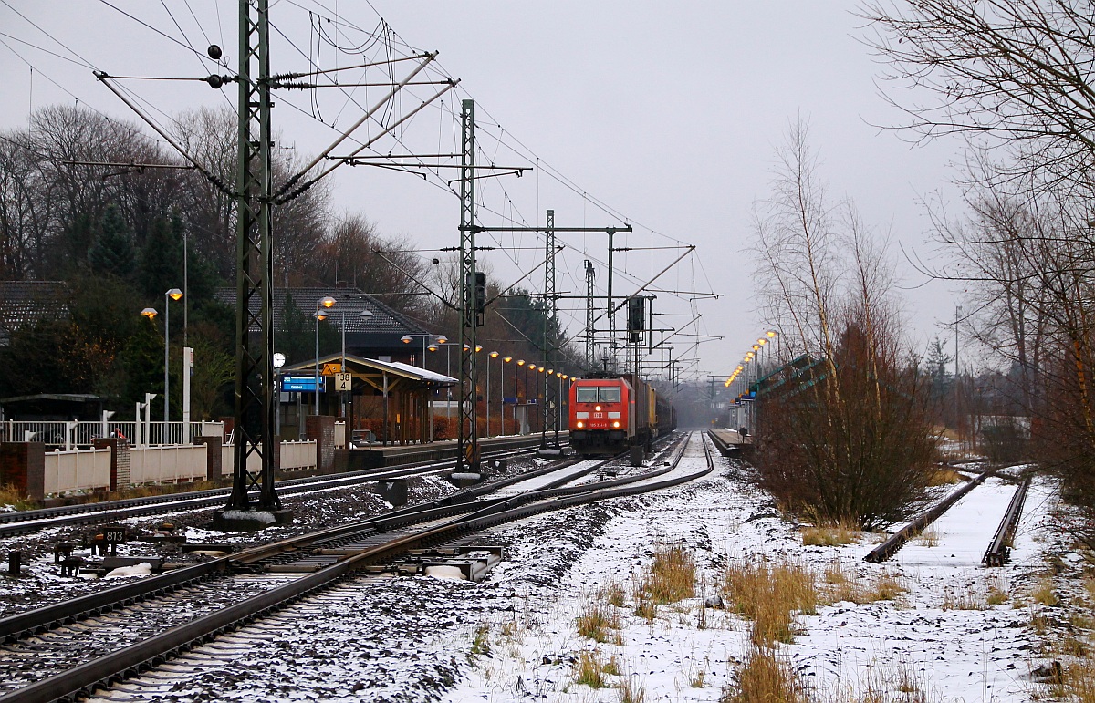 Blick auf den Bahnhof Schleswig mit der wartenden (9186 0)185 324-8(DK-RSC) und ihrem Güterzug vom Bü Karpfenteich(an der Schranke). Rechts ist das vor einigen Jahren gekappte Zufahrtsgleis zum ehemaligen Gbf Schleswig. 08.12.2013