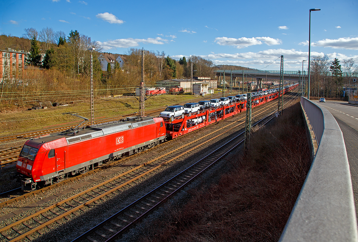 Blick auf den Rangierbahnhof (Rbf) Kreuztal am 23.02.2022, vorne hat die 185 053-6 (91 80 6185 053-6 D-DB) der DB Cargo AG mit einem sehr langen Autotransportzug Hp 0. Der Güterbahnverkehr in Richtung Hagen staute sich etwas in Kreuztal, da die Ruhr-Sieg-Strecke entlang der Lenne (durchs Sauerland) an diesem Tag nur eingleisig befahrbar war. 

Die Wagen von dem Autotransportzug waren Doppelstock-Autotransportwagen der Gattung Laaeffrs 561 (25 80 4382 xxx-x D-ATG) der DB Cargo Logistics GmbH (ex ATG Autotransportlogistic GmbH). 

Die TRAXX F140 AC1 wurde 2002 von Bombardier Transportation GmbH in Kassel unter der Fabriknummer 33461 gebaut.