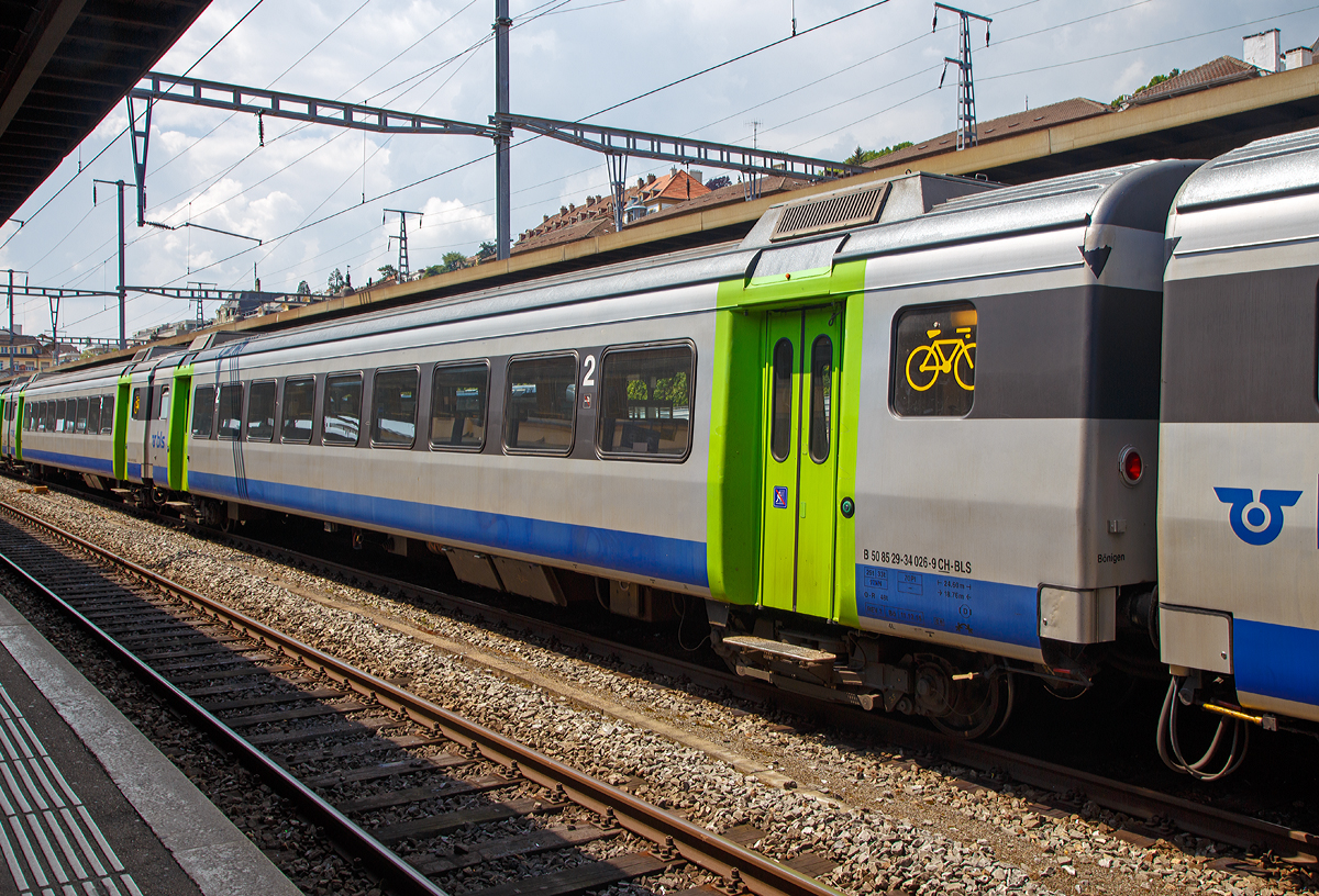 
BLS  2. Klasse Großraumwagen B 50 85 29 - 34 026-9 CH BLS ein Einheitswagen III (EW III) eingereiht am 18.05.2018 in einem BLS EWIII -  Pendelzug im Bahnhof Neuchâtel.

Die Einheitswagen III wurden 1972 bis 1975 gebaut und ab 1975 als Swiss Express mit der unverwechselbaren orange-hellgrauen Lackierung als Städteschnellzüge (heute InterCity) St. Gallen–Genève eingesetzt. Ihre Höchstgeschwindigkeit beträgt 140 km/h und sie waren konstruktiv für den Einsatz von Neigetechnik vorbereitet, die Seitenwände sind dafür auch nach oben hin einwärts geneigt gebaut worden. Sie waren die erste größere Serie klimatisierter Wagen in der Schweiz. Die 29 bis 30 Tonnen schweren Wagen erwiesen sich trotz dieser modernen Merkmale im täglichen Einsatz jedoch als nicht zufriedenstellend.

Es wurden insgesamt 72 Wagen gebaut. Die verbliebenen 57 Wagen wurden per Fahrplanwechsel 2004 an die BLS Lötschbergbahn verkauft und danach im Innenraum modernisiert. Die BLS ließ noch je zwei A-Wagen zu Zweitklasse-Steuerwagen und zu Endwagen umbauen. Somit existieren insgesamt neun Steuerwagen. Bis Dezember 2004 waren alle Wagen in den neuen BLS-Farben lackiert worden und seither werden sie im RegioExpressverkehr Bern–Langnau–Luzern und Bern–Neuchâtel eingesetzt. Im Gegenzug kauften die SBB die Einheitswagen IV der BLS. Von 2004 bis 2010 trugen die Wagen BLS-UIC-Nummern (50 63 …), seither tragen sie TSI-Nummern mit dem Landescode 85, die nicht umgebauten Fahrzeuge haben dabei wieder ihre alten Nummern erhalten. 

Ein sechsteilige Pendelzug- Komposition bietet 320 bis 343 Sitzplätze, die Wagenübergänge sind dabei stufenlos begehbar. Geschwindigkeiten von bis zu 140 km/h garantieren zudem attraktive Fahrzeiten.

TECHNISCHE DATEN:
Spurweite: 1.435 mm (Normalspur)
Wagenlänge über Puffer:  24.600 mm
Drehzapfenabstand: 18.760 mm
Eigengewicht: 29 t
Sitzplätze: 70 in der 2. Klasse
Besonderheit: Fahrradabteil