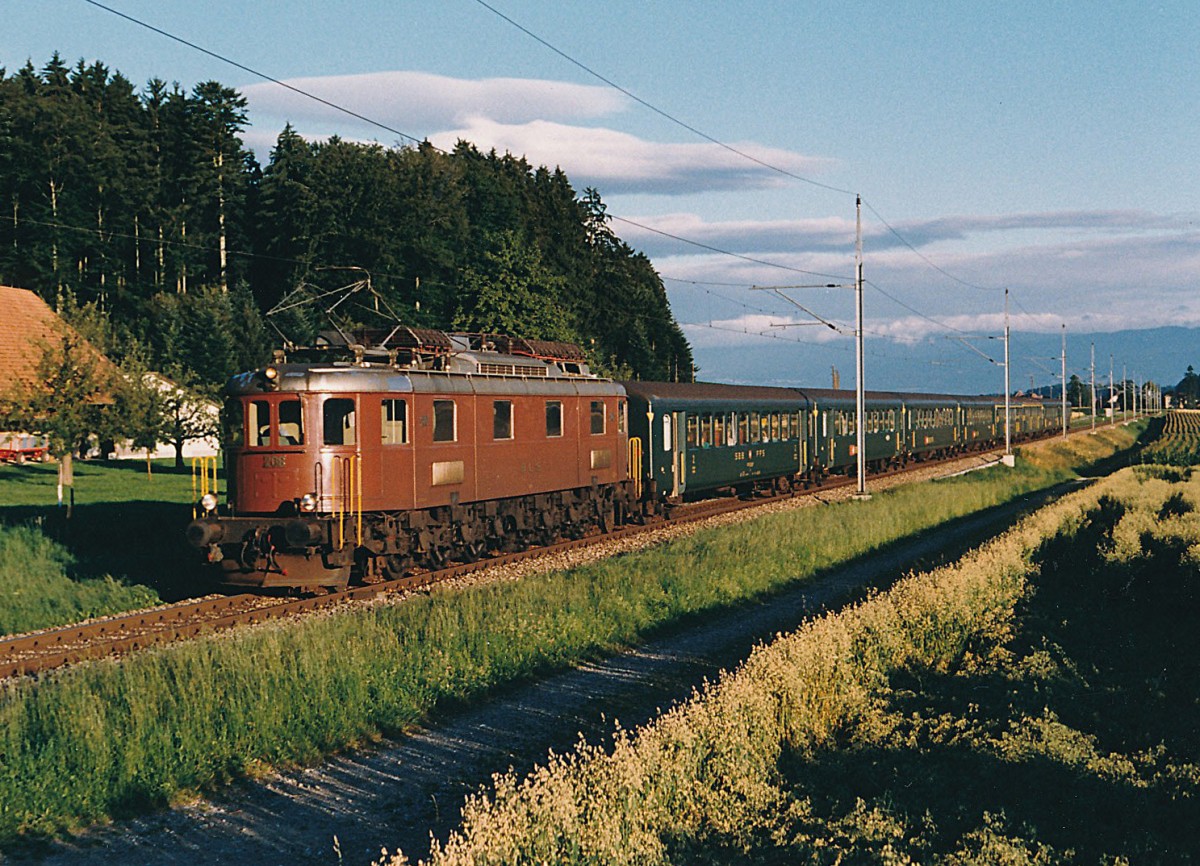 BLS/SBB: Morgenschnellzug Biel-Bern mit BLS Ae 6/8 208 und SBB EW ||-Wagen. Die Aufnahme ist in der Morgensonne zwischen Schüpfen und Münchenbuchsee im Juli 1986 entstanden.
Foto: Walter Ruetsch