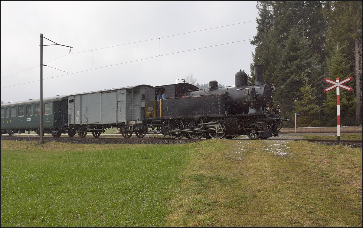 Dampflok Ed 3/4 Nr. 2 der Solothurn-Münster-Bahn bei Häusernmoos. Betreut wird die Lok durch den Verein historische Emmentalbahn. Mit im Gepäck hat sie zwei vierachsige Leichtstahlplattformwagen und einen K2. Februar 2018.